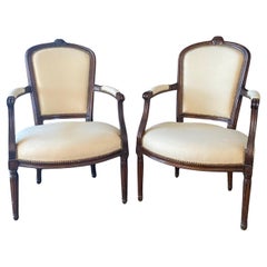 Paire de fauteuils ou fauteuils en noyer Louis XVI sculptés à la main