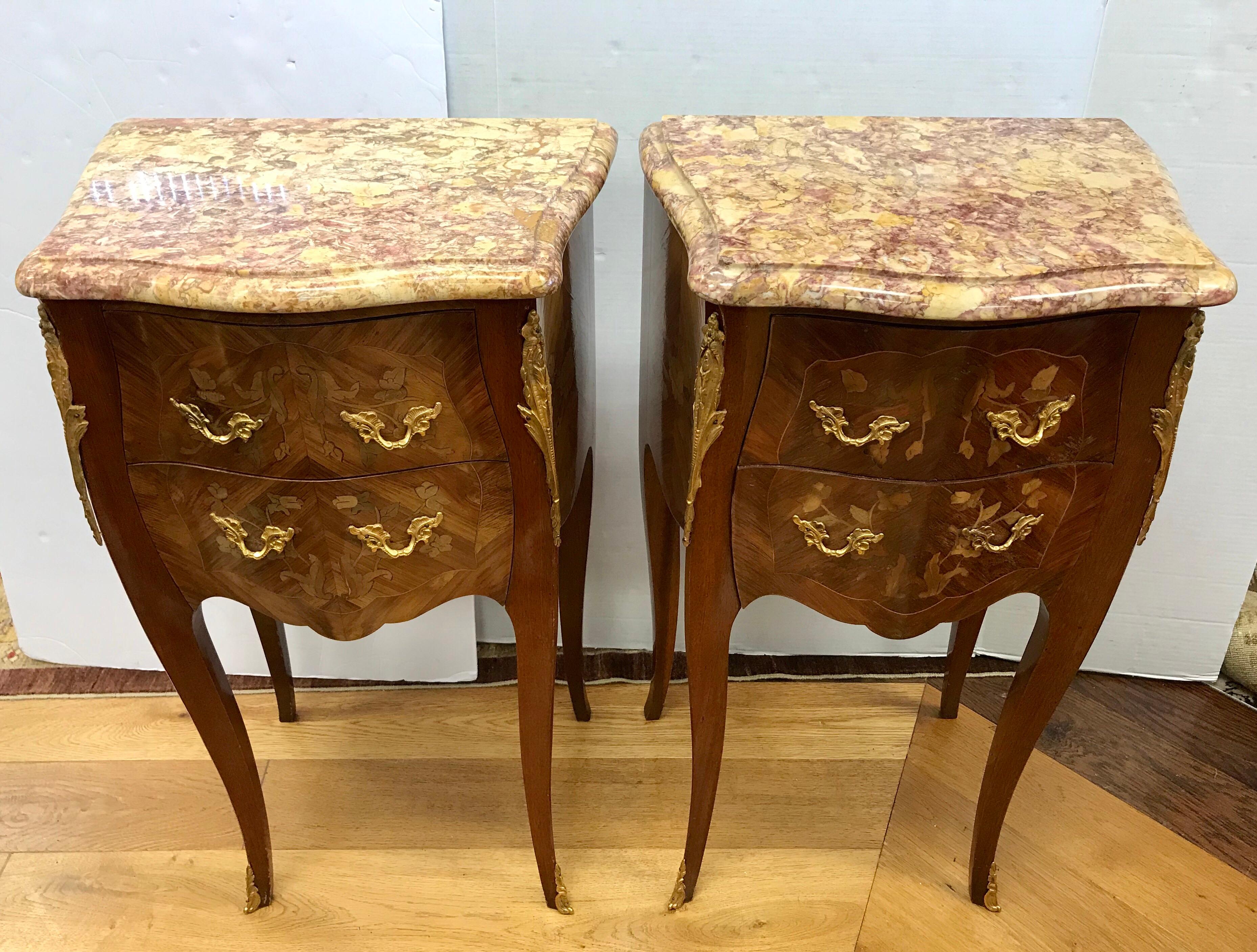 A stunning pair of French Louis XVI style parquetry marble-top two drawer bedside tables or nightstands with bronze mounts and marble tops. Beautiful floral marquetry on front and sides.