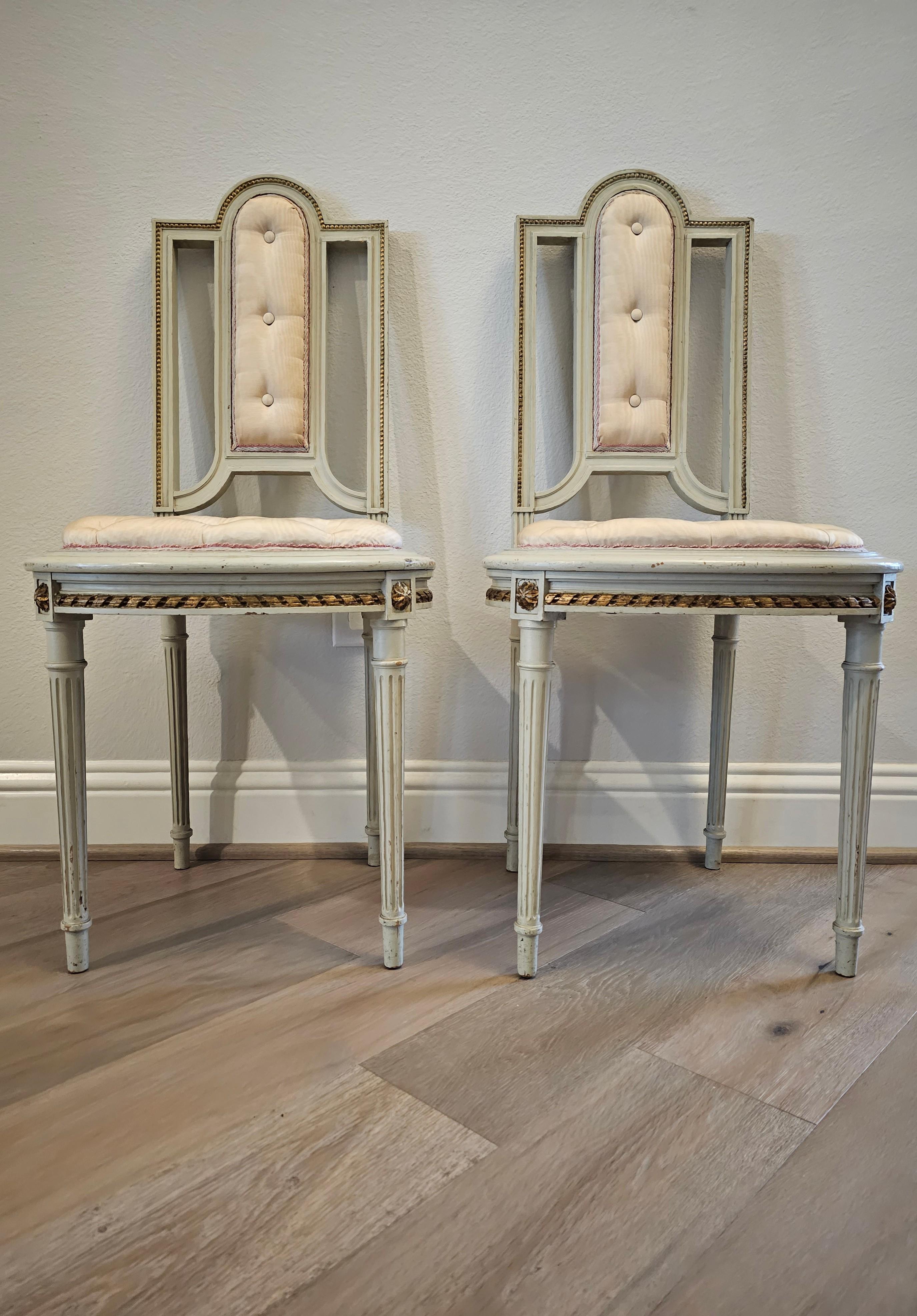 An elegant pair of petite French Belle Époque period (1871-1914) Louis XVI style parcel gilt painted chairs.

Hand-crafted in France in the late 19th / early 20th century, executed in luxurious Louis 15th style, featuring a solid wood frame carved