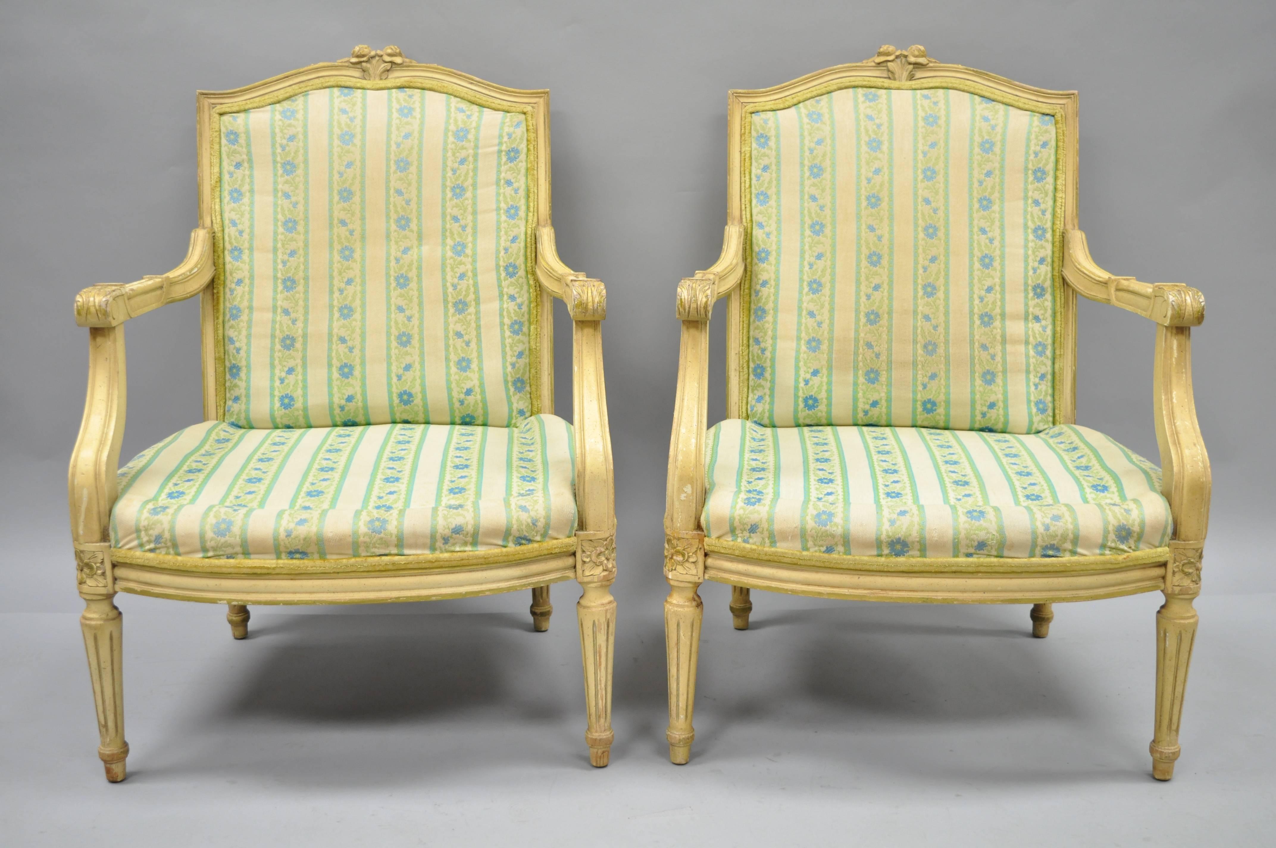 Pair of vintage French Louis XVI Provincial style cream painted armchairs. Item features solid wood construction, cream distress painted finish, nicely carved details, tapered legs, great style and form, circa mid-20th century. Measurements: 35.5
