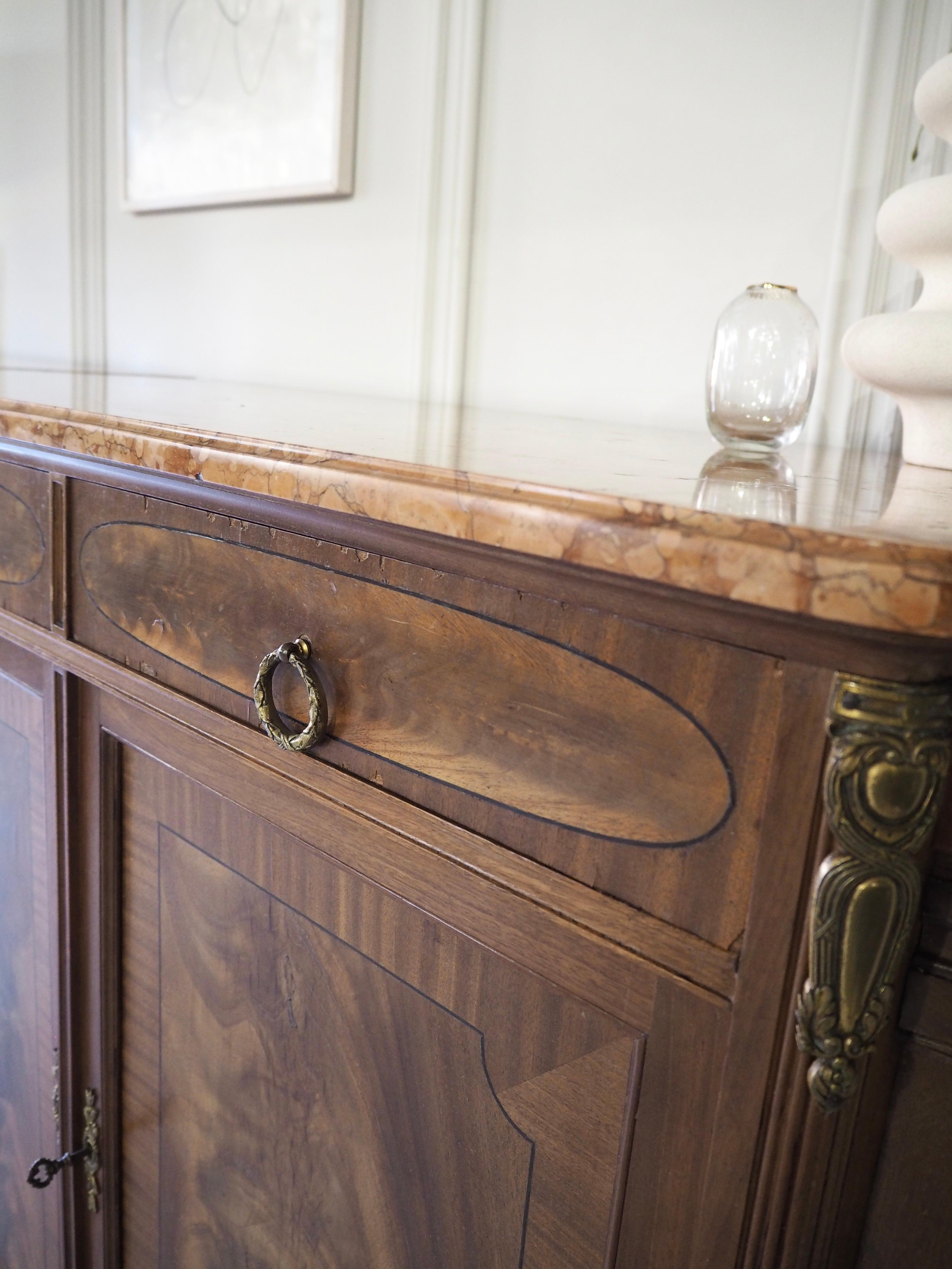 A lovely large French sideboard in Louis XVI style with a marble top, compromising of four cupboard doors and four internal drawers. The central drawers open outwards to reveal a large internal shelf, with the right hand side cupboard housing two