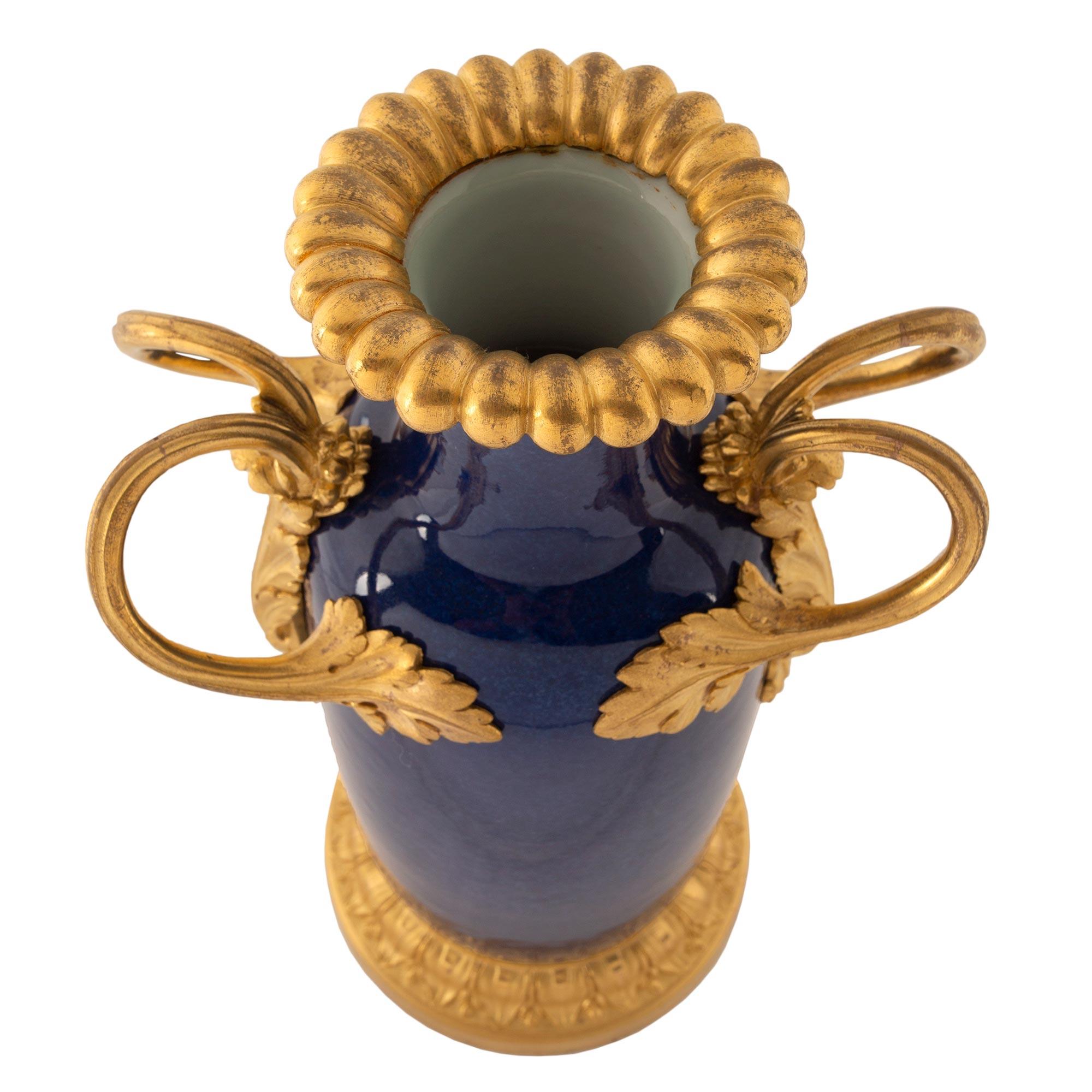 A fine pair of French Louis XVI st. 19th century cobalt blue and ormolu mounted vases. The pair are raised by a circular mottled ormolu base with an elegant Coeur de Rai design. The rich cobalt blue urns are flanked by two scrolled ormolu handles in