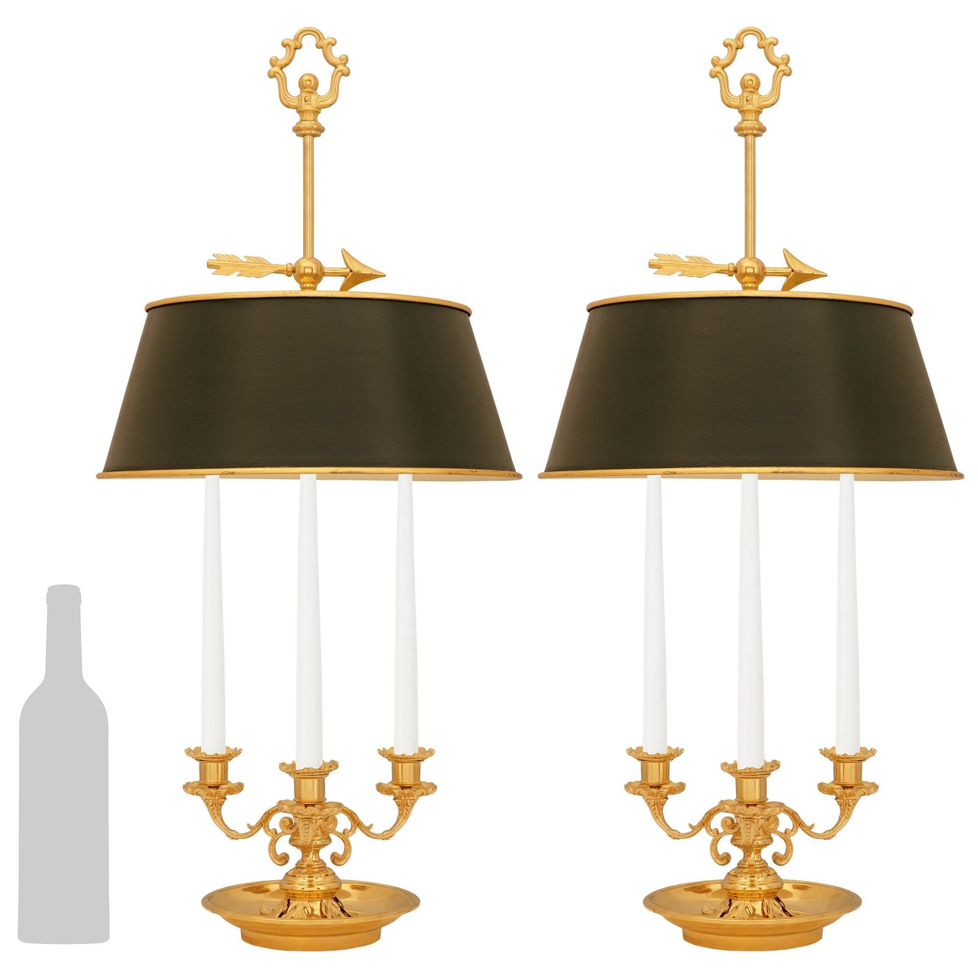 Un'affascinante coppia di lampade francesi di fine secolo Luigi XVI in Ormolu e Tole Bouillotte. Ogni elegantissima lampada a candelabro non elettrificata è sollevata da un piattino in Ormolu ornato da foglie d'acanto finemente cesellate sotto il