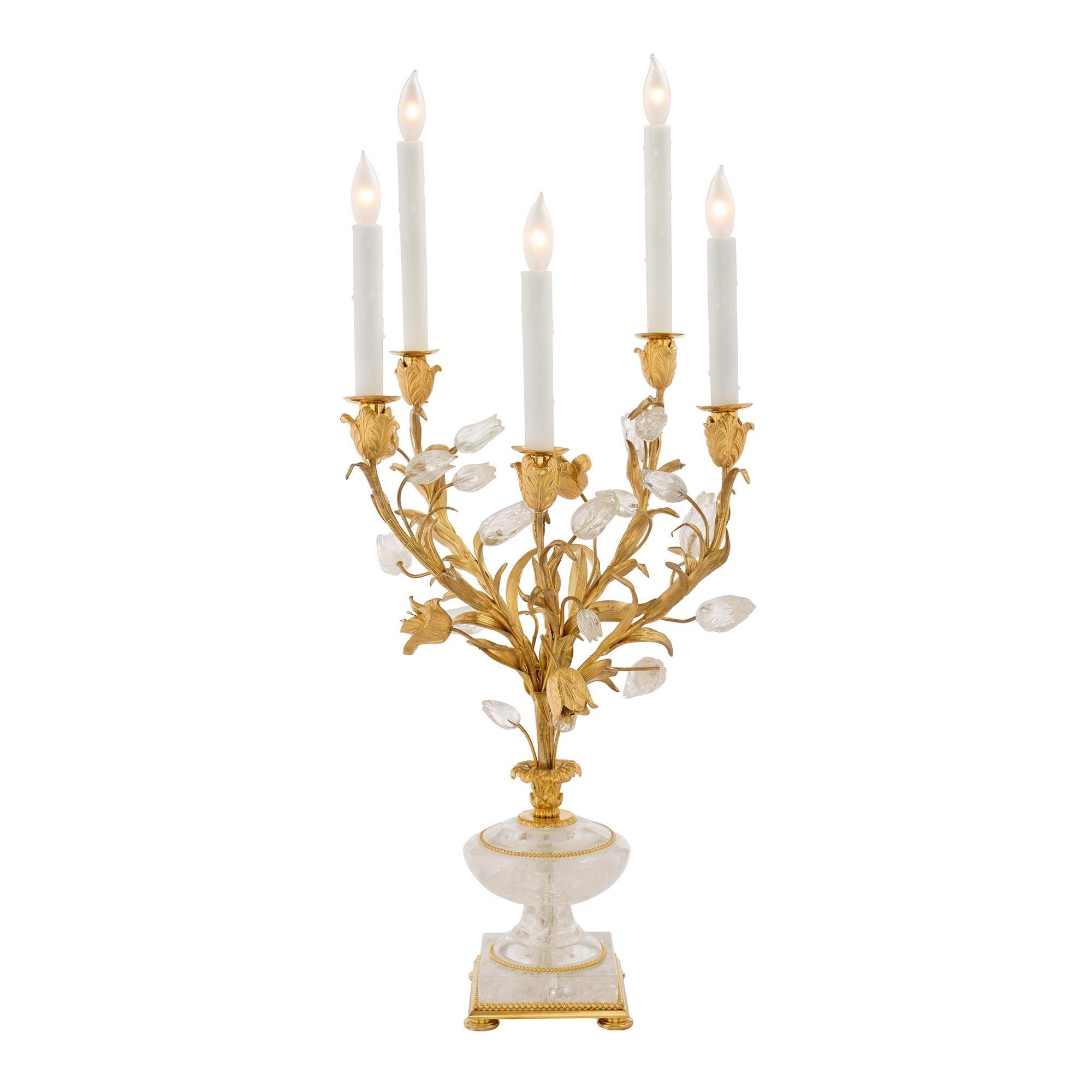 An exquisite and very high quality pair of French Louis XVI st. Rock Crystal and ormolu candelabra lamps. Each lamp is raised on ormolu bun feet and beaded trim support. Above is a stunning Rock crystal square base and a baluster shaped body