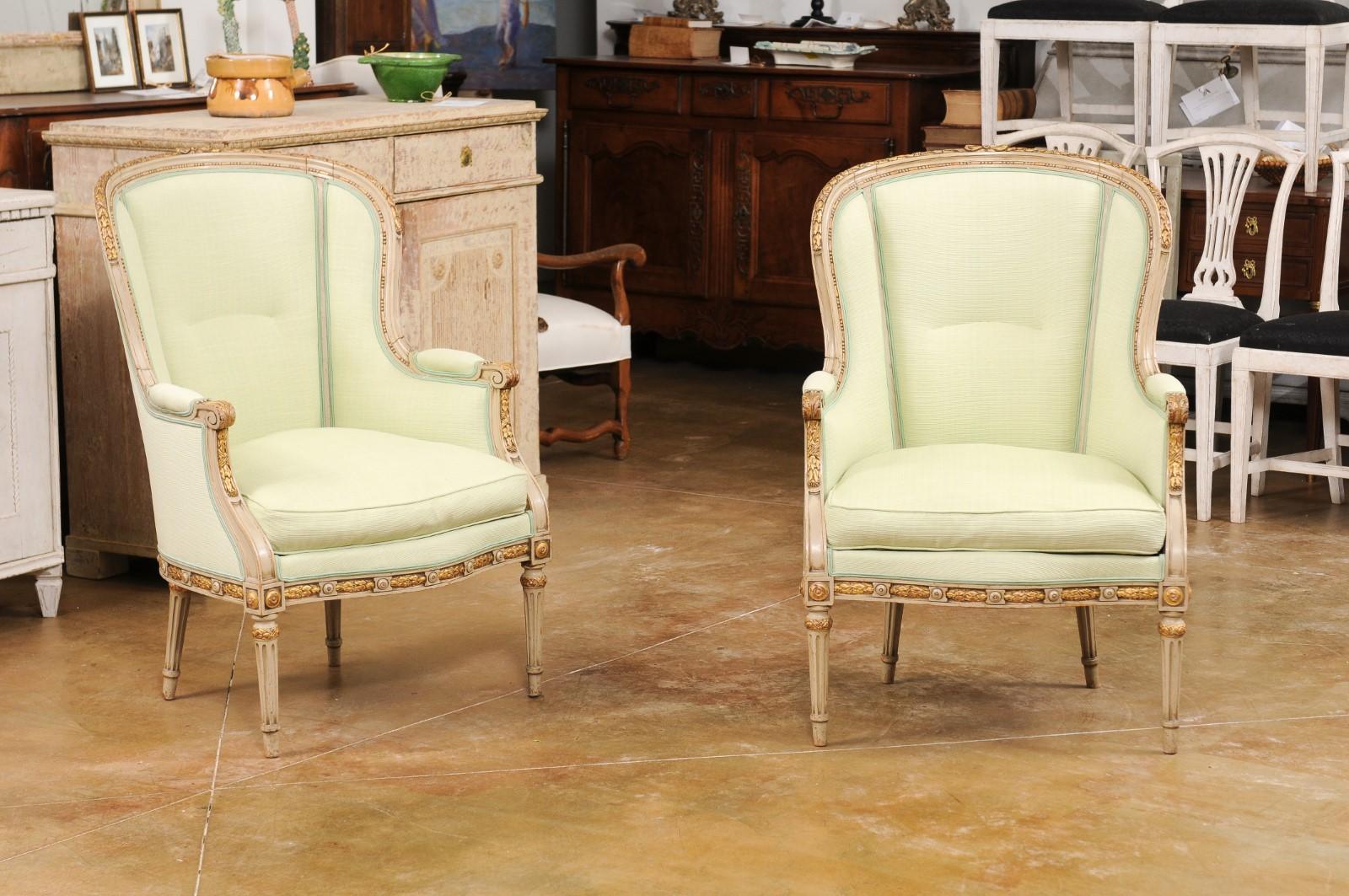 Carved Pair of French Louis XVI Style 1900s Painted and Parcel-Gilt Bergères Chairs For Sale