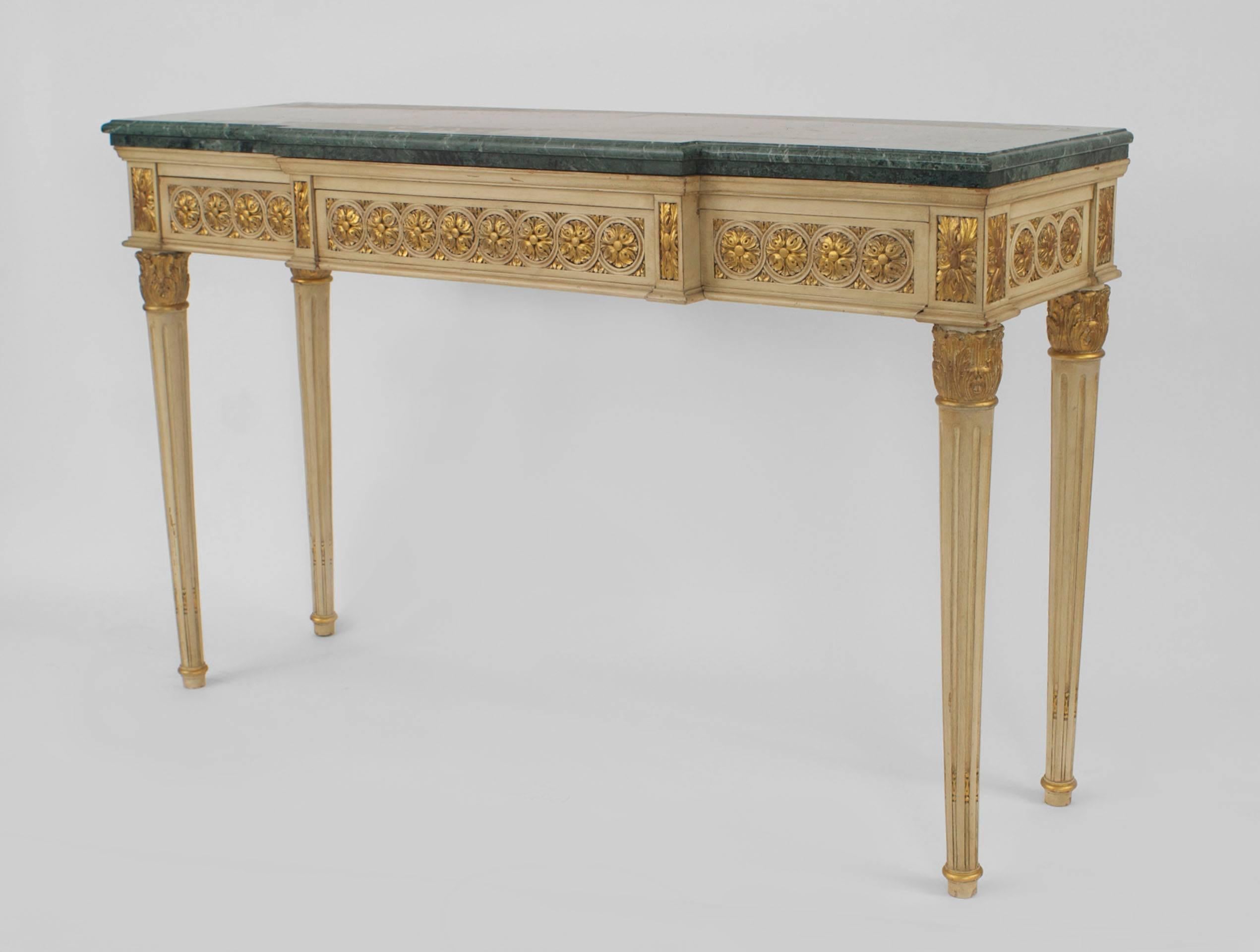 Pair of French Louis XVI style, 1940s off-white painted and gilt carved console tables with a breakfront and supporting marble tops (stamped: JANSEN).

  