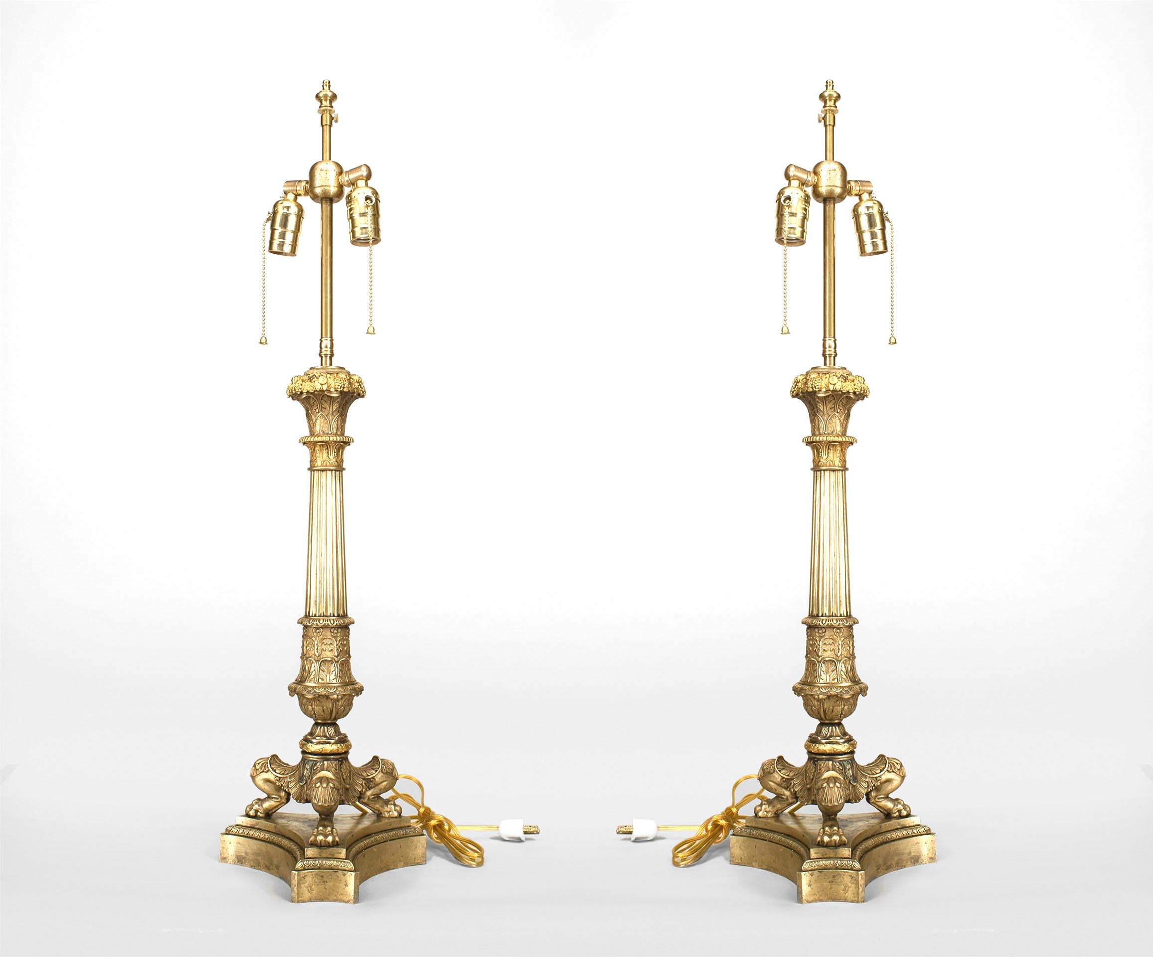 Pair of French Louis XVI style (19th century) gilt bronze table lamps with a tall fluted column supported on three feet and resting on a triangular base (originally candelabra).
 