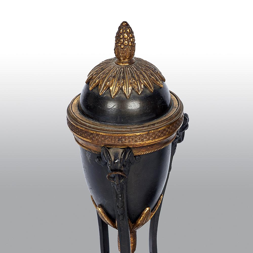 Ein Paar Cassolettes aus Bronze und Ormolu im Stil Louis XVI. Jeweils in Form einer Athenienne, mit reversiblen Oberteilen mit Knospenabschluss und Kerzenleuchter, die Körper fein verziert und mit Widderkopf-Monopodien unterstützt.