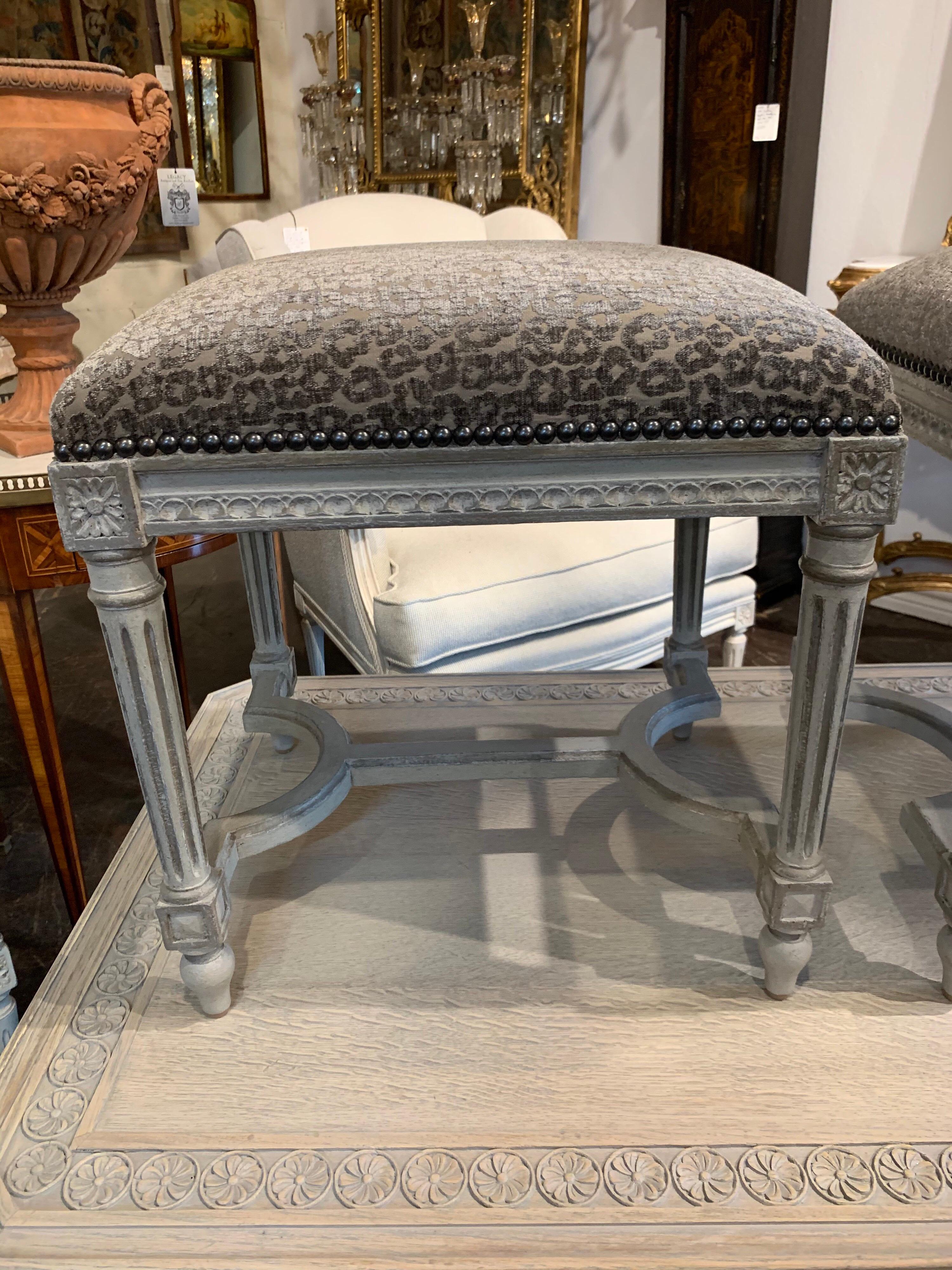 Very pretty pair of French Louis XVI style carved and painted stool. These are painted in light grey and upholstered in a nice animal print. Beautiful patina on the finish. A stylish pair that fits well in a multitude of decors!