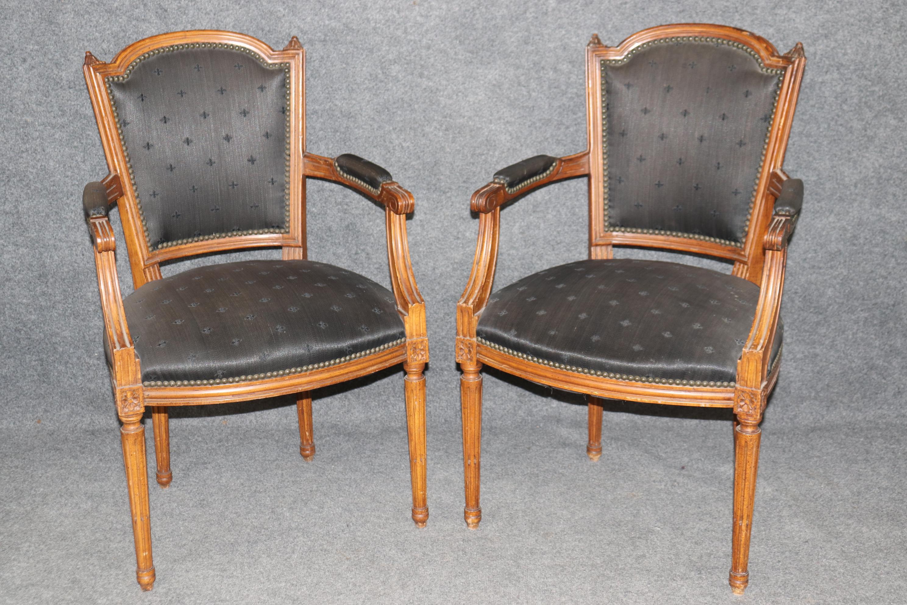 Dimensioni - H: 37 3/4 in L: 23 in P: 22 1/2 in SH: 19 1/2 in

Questa squisita coppia di poltrone aperte in stile French mid 20th XVI incarna un'eleganza senza tempo e una maestria artigianale. Le sedie sono sapientemente costruite in legno di noce