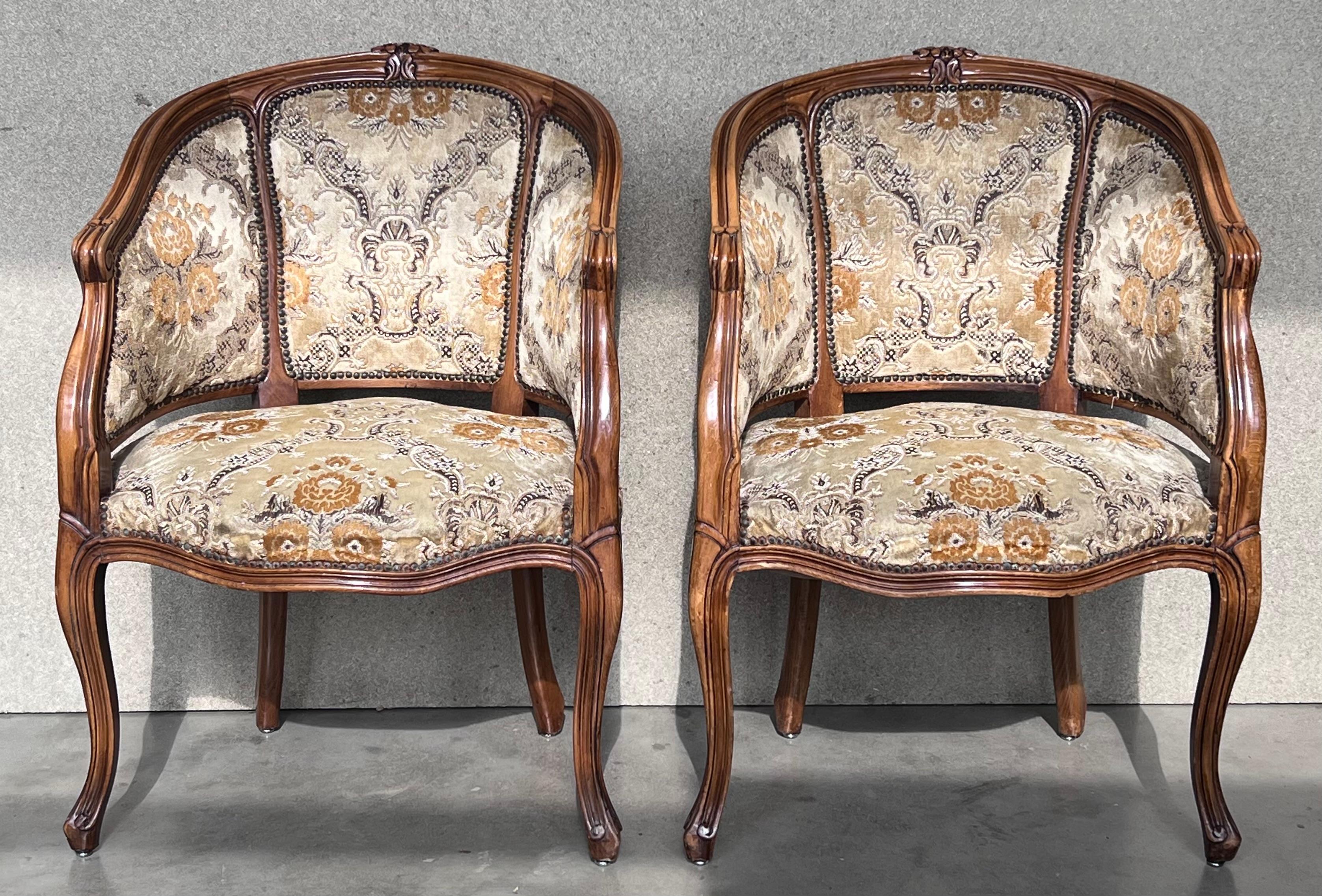 Whimsical pair of painted French Bergere armchairs made in the grand Louis XVI taste. The armchairs feature a barrel back form with a molded frame having neoclassical laurel swag decoration on the seat apron. The gracefully curved back ends with