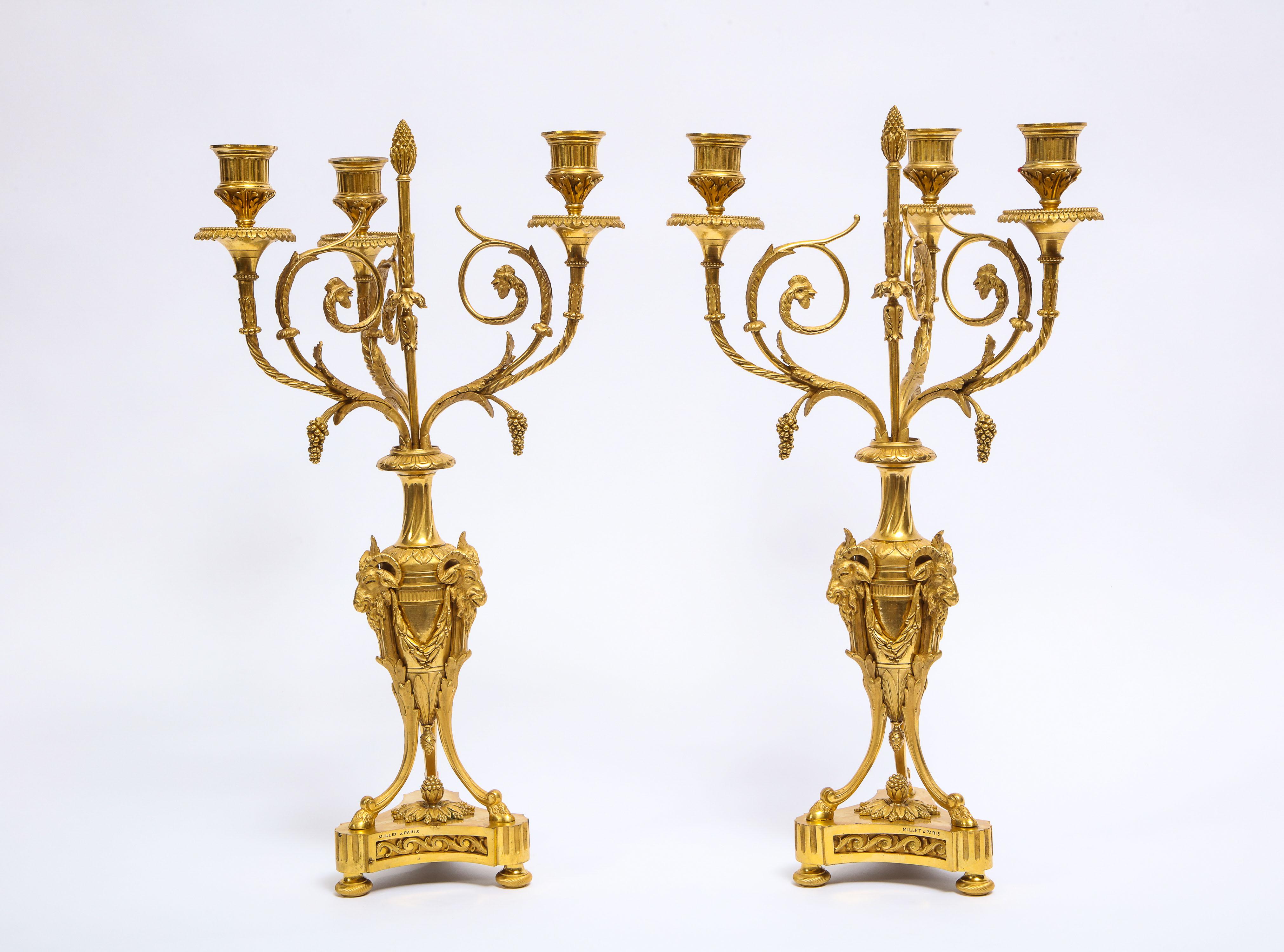 A fabulous pair of antique French Louis XVI style, doré bronze three-arm candelabras. Each candelabra finely casted, and further enhanced with the finest quality of doré bronze and hand-chasing, leading to an elaborate amount of detail to each
