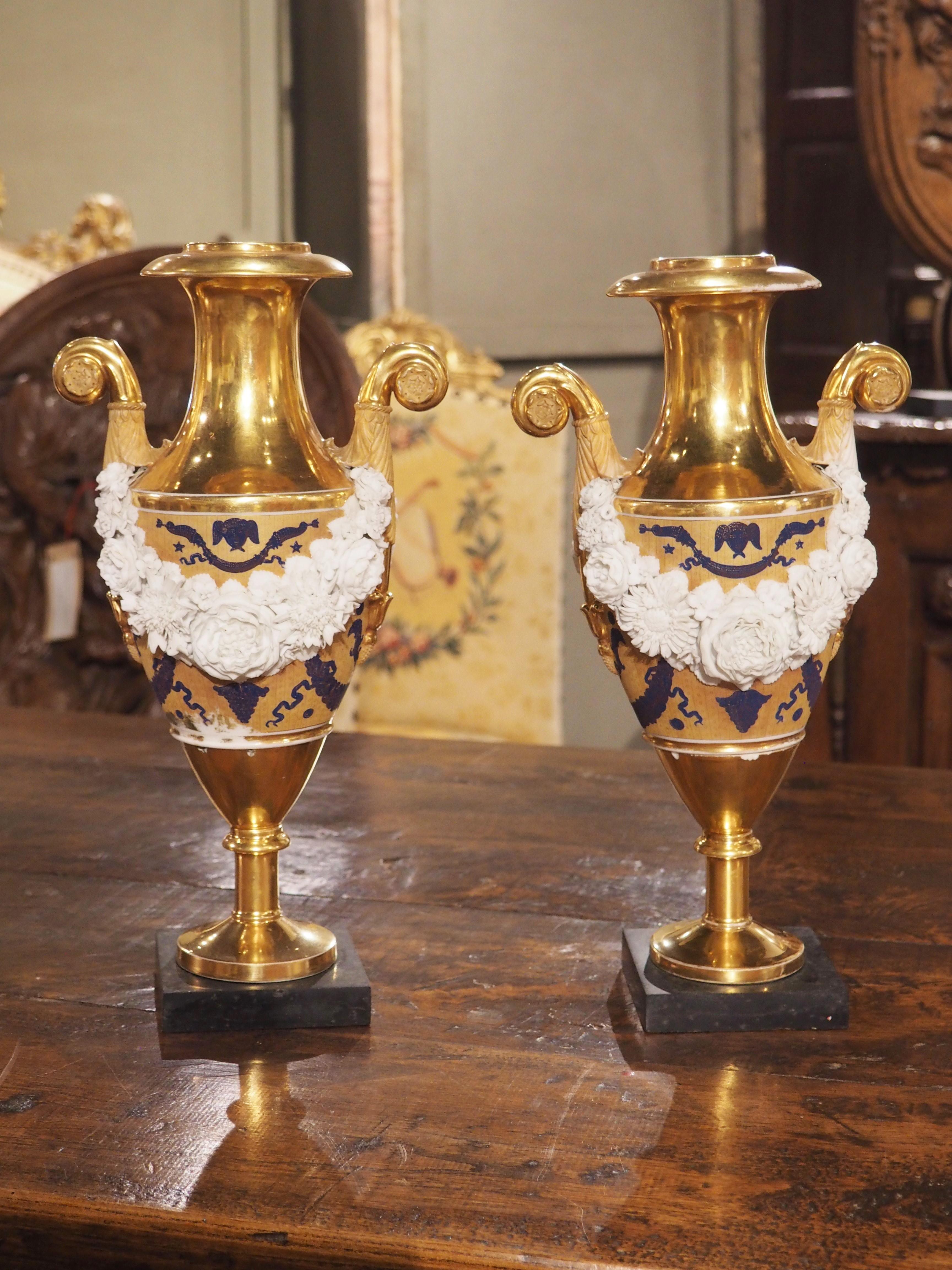 Avec ses éléments néoclassiques, cette paire de vases en porcelaine française est de style Louis XVI. Fabriqué vers 1870, les détails étonnants des guirlandes sont mis en valeur par la riche coloration des éléments peints à la main et de la