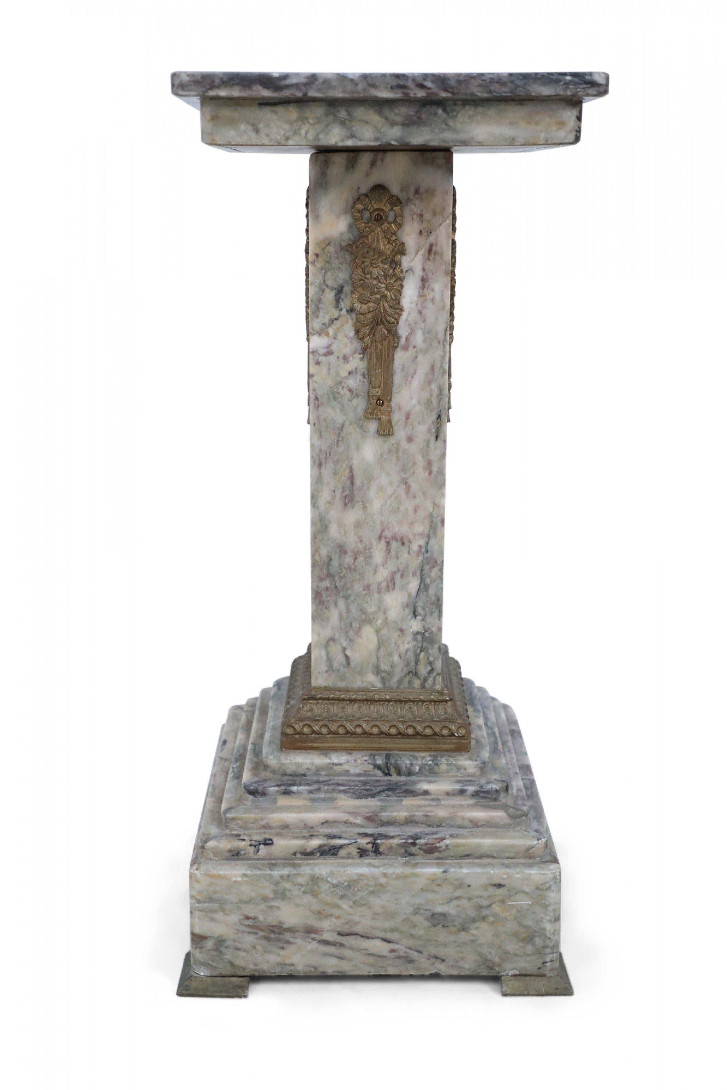 Pair of French Louis XVI-style (19th Century) gray marble pedestals with square tops and bases, bronze bow-knot and tassel embellishments on the sides, and a decorative bronze band around the bases (PRICED AS Pair).

Noticeable Repair of marbles