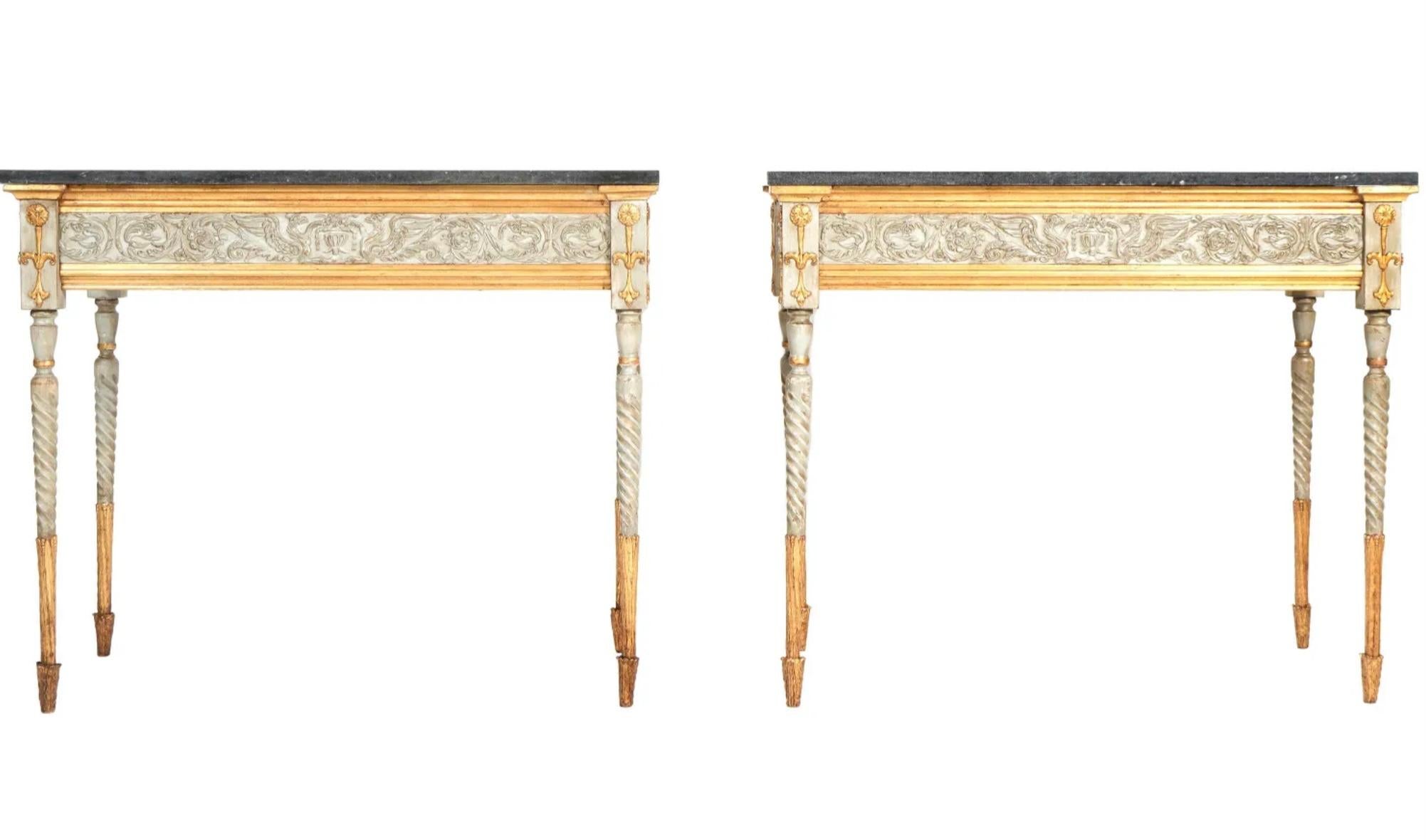 Pair of 19th French Neoclassical marble top and painted console tables. Tables are cream and gold in color with original carvings. They have black and green marble tops and are raised on tapered fluted legs. 