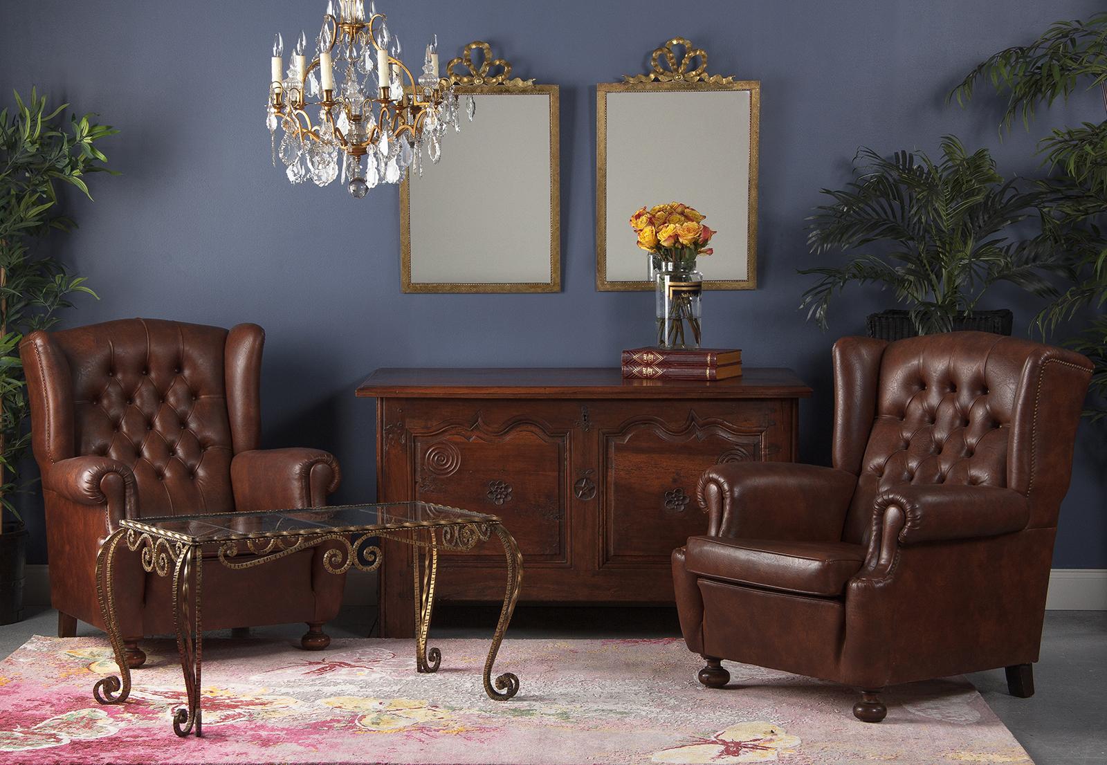 A pair of gorgeous mirrors with brass frames made in the Louis XVI style with arabesque motifs, beading around the glass and a ribbon motif at top. The mirrors tilt forward a couple of inches due to brass rings behind the frames. The mirrored glass