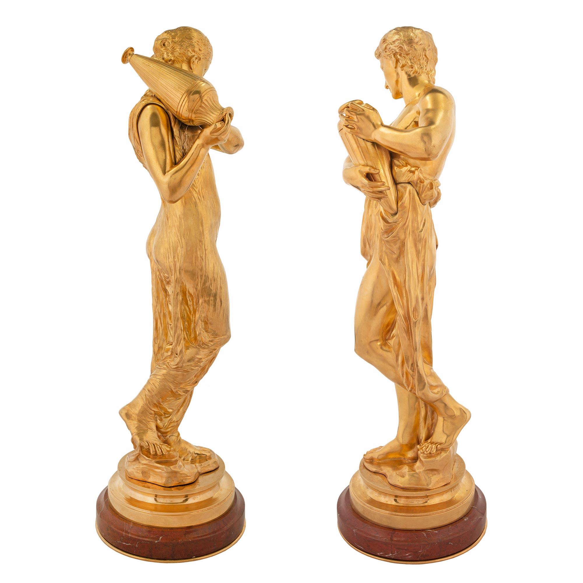 Français Paire de statues de style Louis XVI en bronze doré et marbre griotte rouge en vente