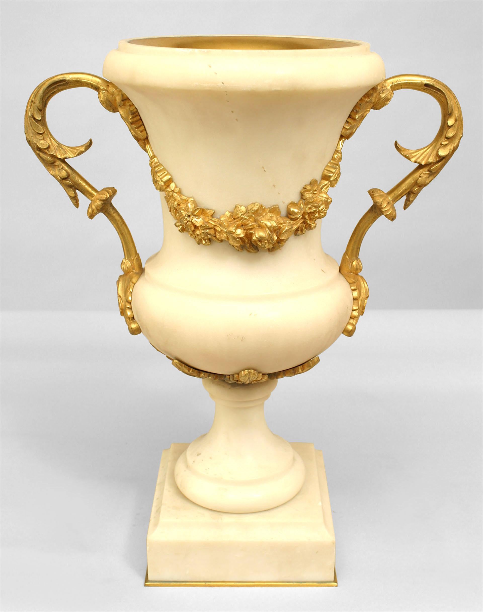 Pair of French Louis XVI style ormolu mounted white marble urns hung with berried floral garlands (early 20th Cent) (PRICED AS Pair)
