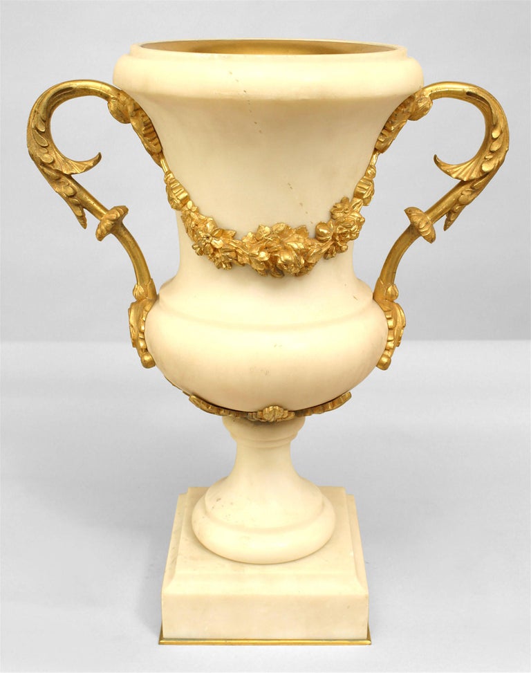 Pair of French Louis XVI style ormolu mounted white marble urns hung with berried floral garlands (early 20th Cent) (PRICED AS Pair)
