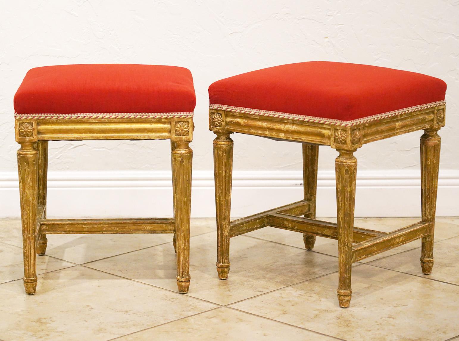 With their Venetian red seats this elegant pair of French Louis XVI style benches or stools are truly spectacular. Connected by fluted seat frames they rest on round tapering fluted legs topped by carved rosettes and united by lower stretchers. The