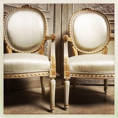 Pair of French Louis XVI Style Painted and Parcel Gilded Fauteuils