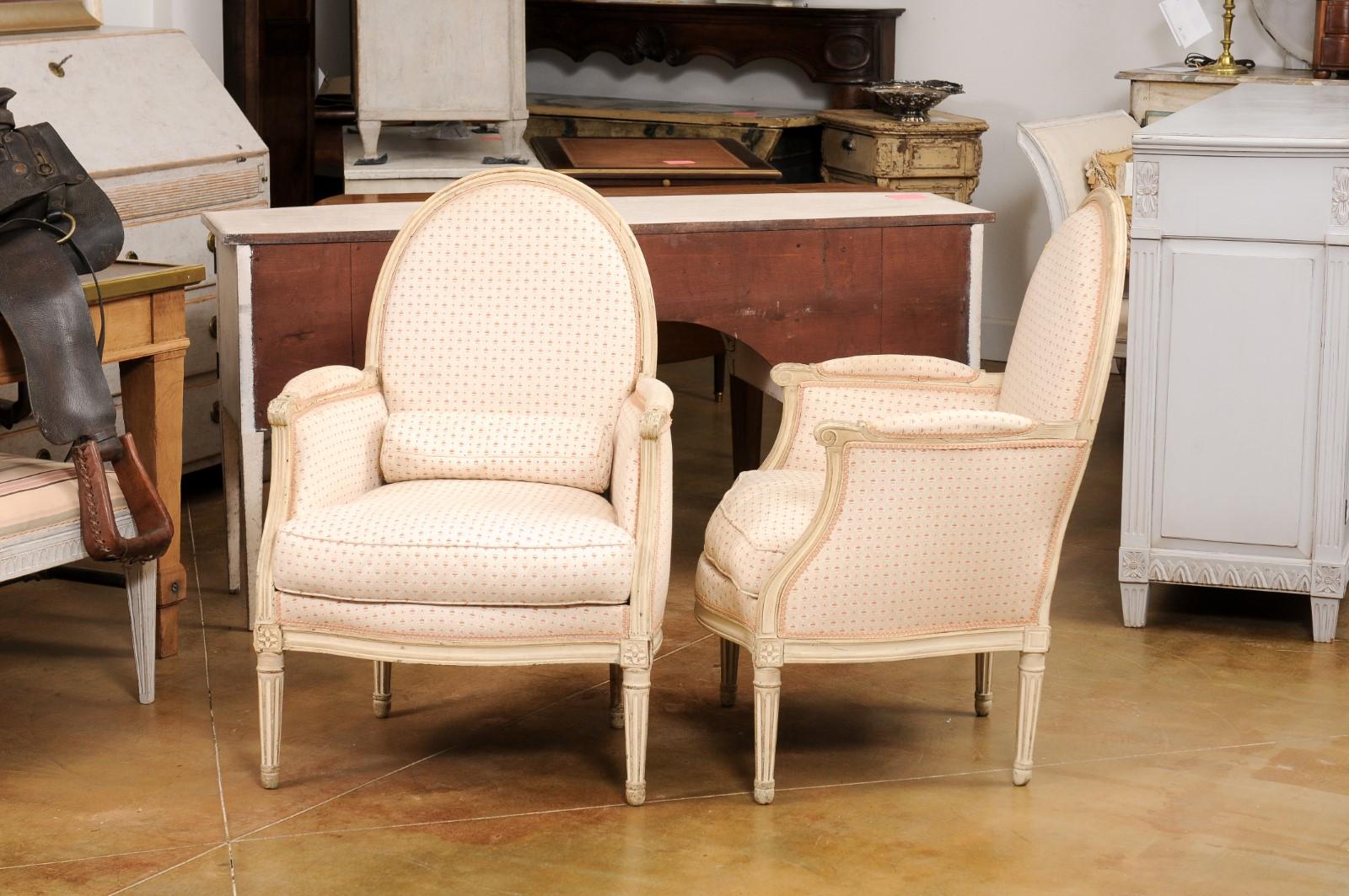 Carved Pair of French Louis XVI Style Painted Bergères Chairs with Oval Shaped Backs For Sale