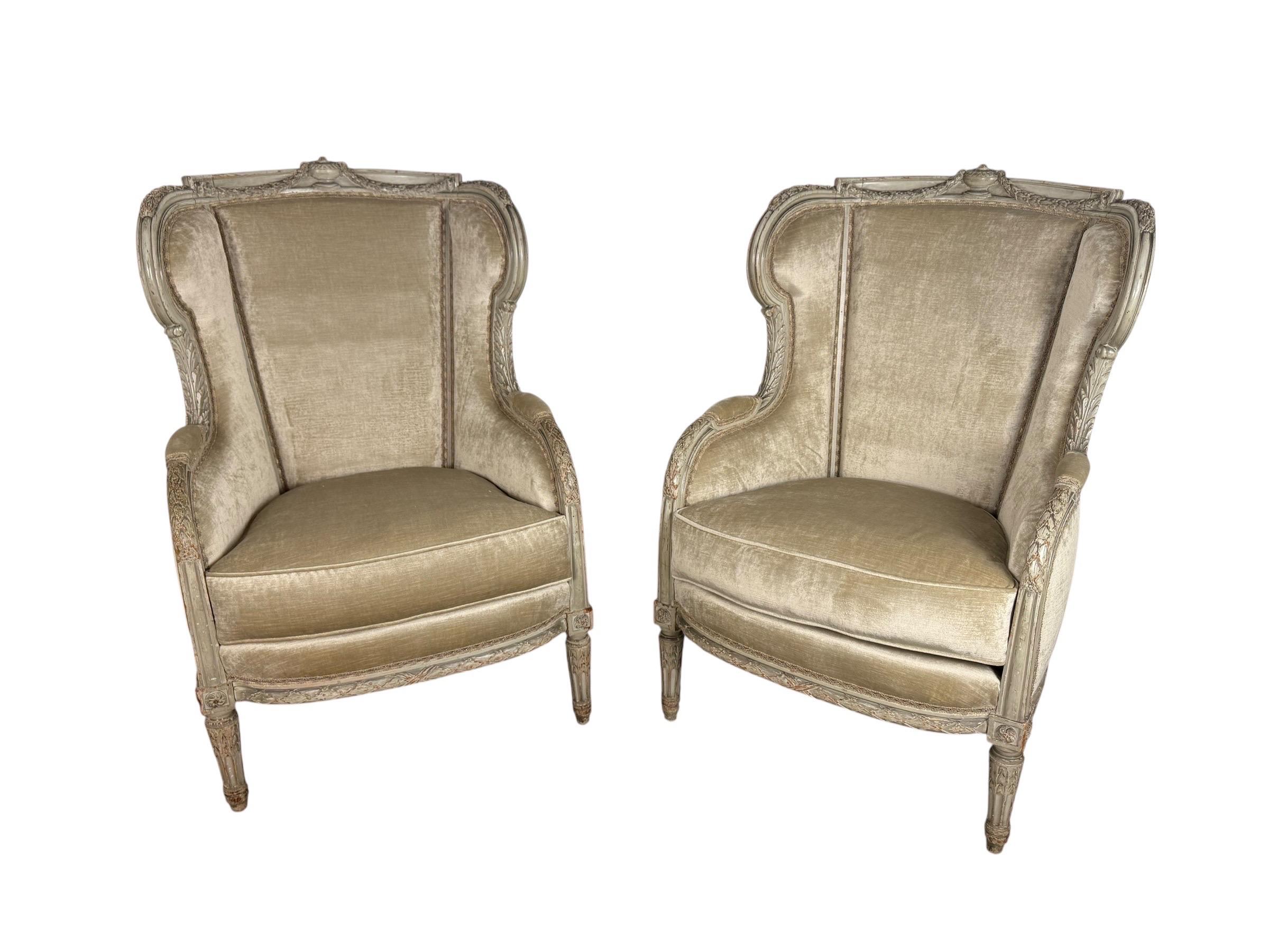 Elegantes Paar französischer Bergstühle im Louis-XVI-Stil, spätes 19. bis frühes 20. Jahrhundert, mit fein geschnitzten Rahmen in zartem graugrünem Anstrich mit charmanten Gebrauchsspuren und altersgemäßer Abnutzung. Die Stühle haben eine geformte