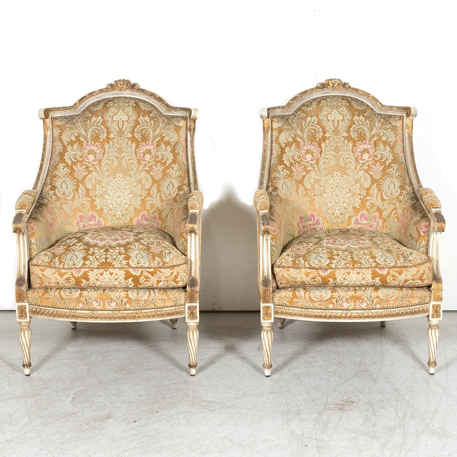 A beautiful pair of early 20th century French Louis XVI style bergère chairs with loose seat down filled cushions and nail head trim handcrafted in Paris and attributed to the distinguished French atelier, Maison Jansen, circa 1920s. Having timeless