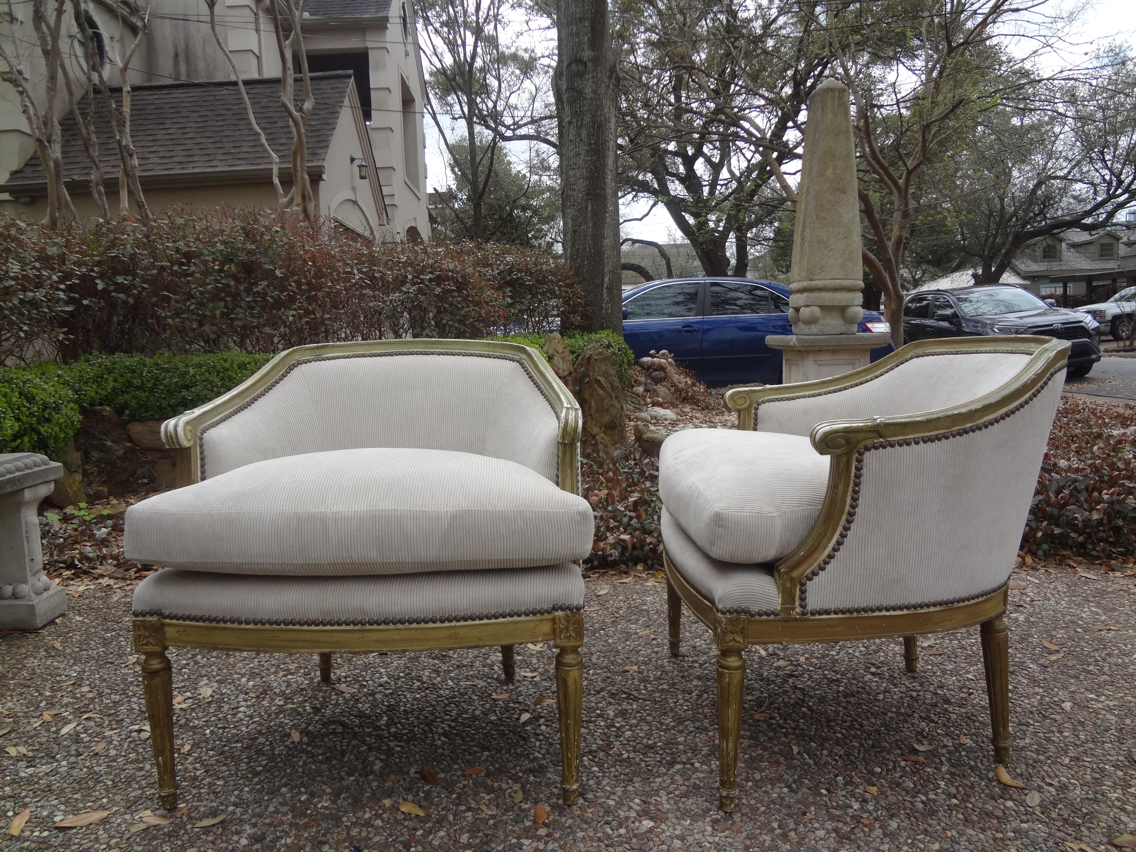 Stunning pair of antique French Louis XVI style polychromed bergère. Our pair of French bergère chairs have been professionally upholstered in a beautiful neutral taupe cut velvet in a corduroy style pattern with brass nail head detail. This clean