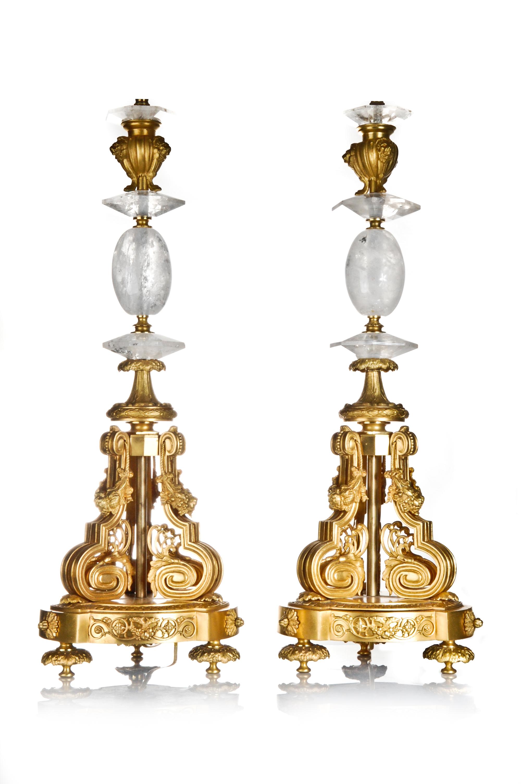 Une paire de spectaculaires lampes françaises de style Louis XVI en cristal de roche taillé et bronze doré, ornées de fleurs et de masques figuratifs.