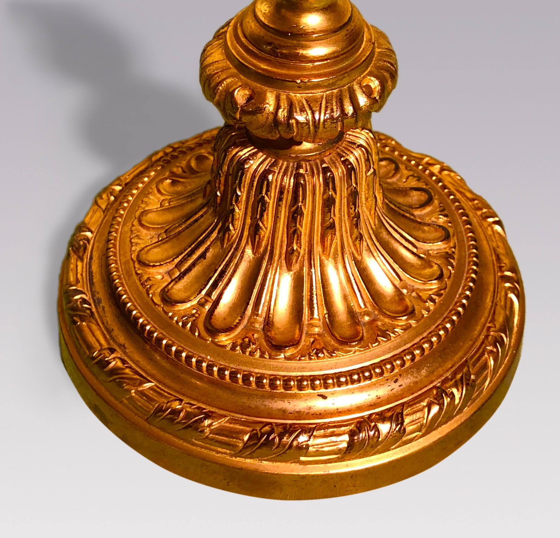 Une paire de candélabres français de style Louis XVI en bronze doré à trois lumières avec une décoration perlée sur toute la surface, avec des tiges cannelées décorées de guirlandes se terminant sur des bases circulaires cannelées.