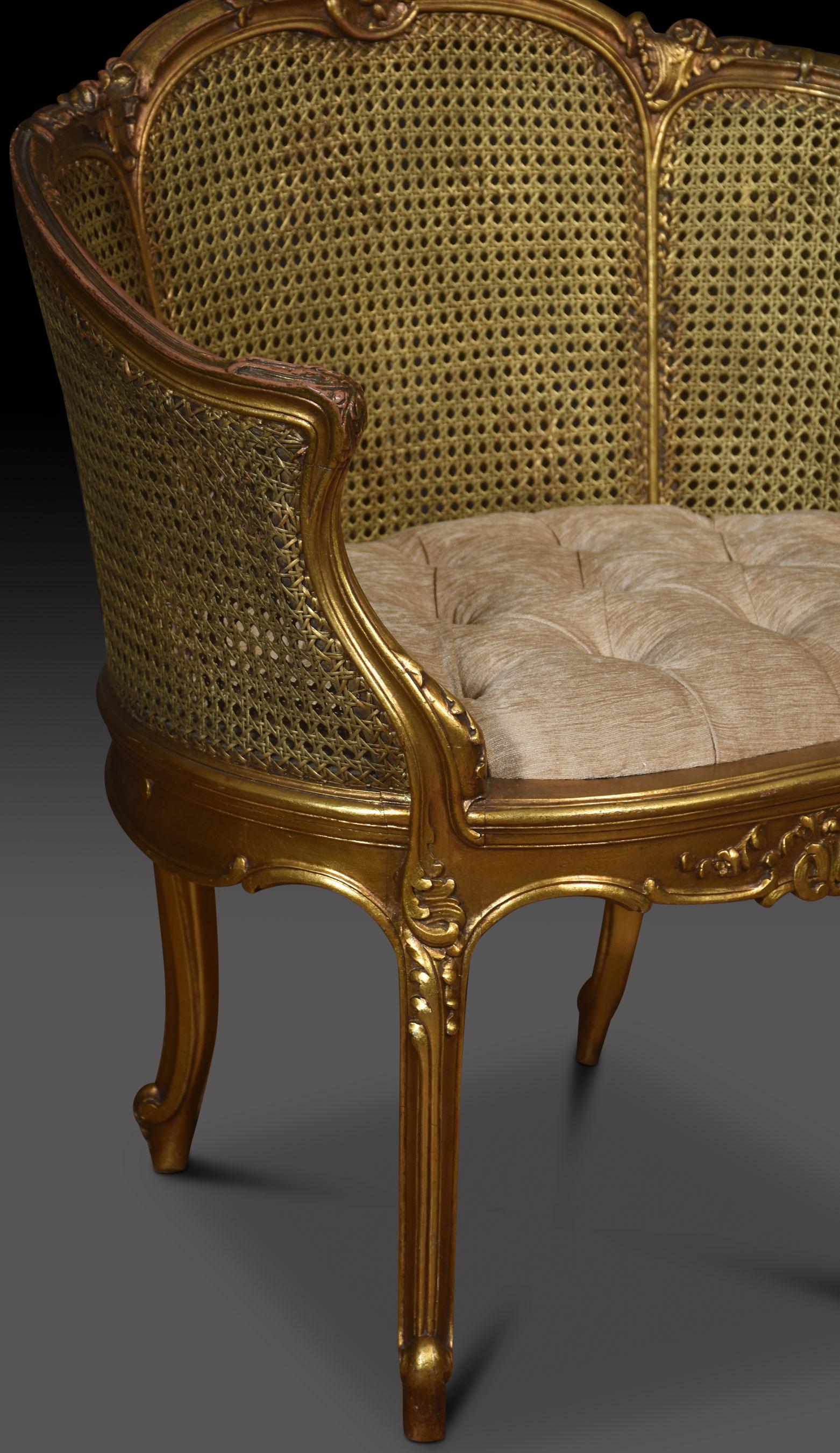 Pair of French Louis XVI style tub armchairs, the carved gilded rail in the typical manner of the period, the frame a repeating motif of detailed leaves. To the scrolling acanthus caped arms, flanking around the bergere back and arms, with
