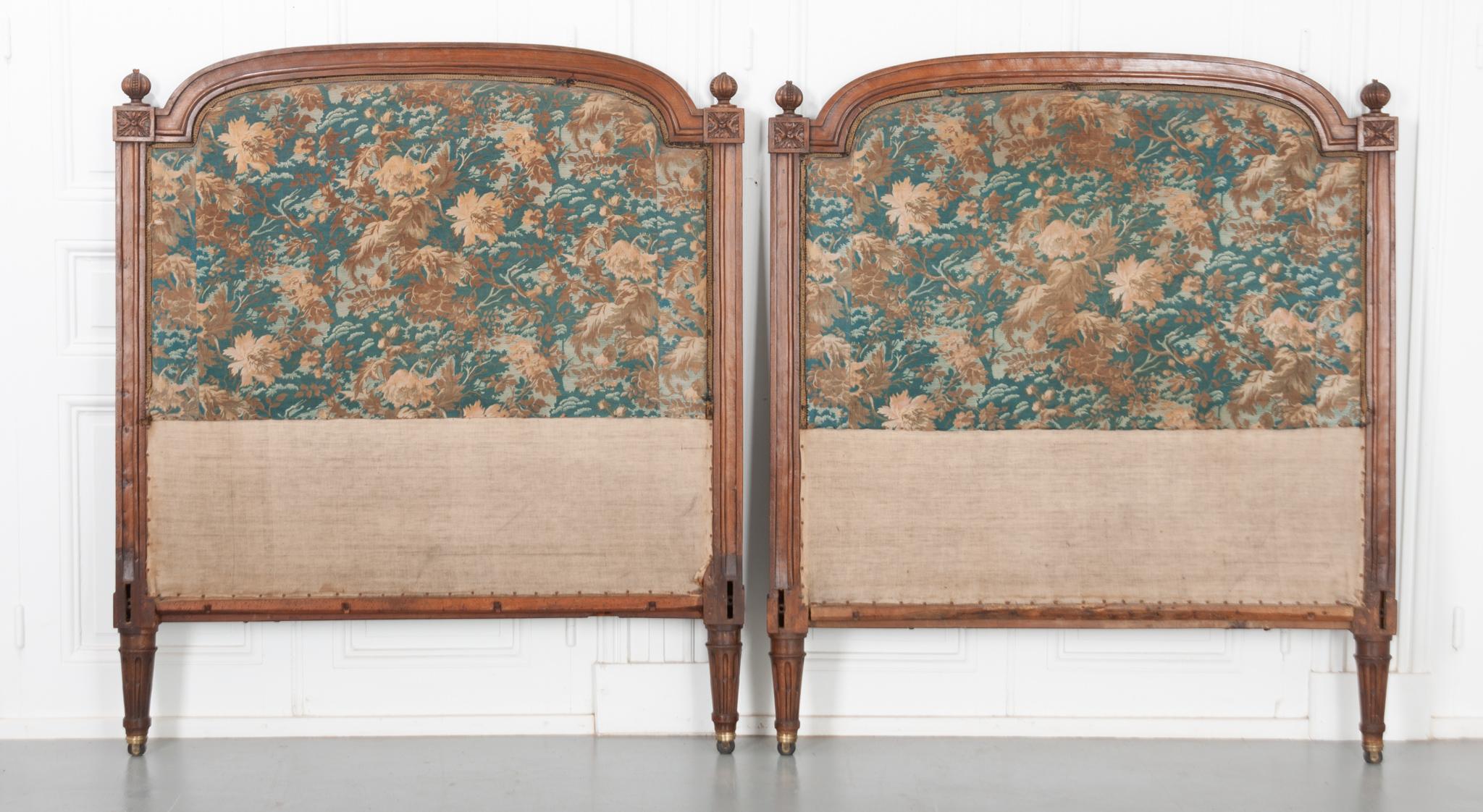 This pair of headboards are made of beautifully carved walnut and original upholstery from the 19th Century. The wood has a wonderful tone and patina. It has square, fluted columns on each side with an intricately carved square with a rossett and
