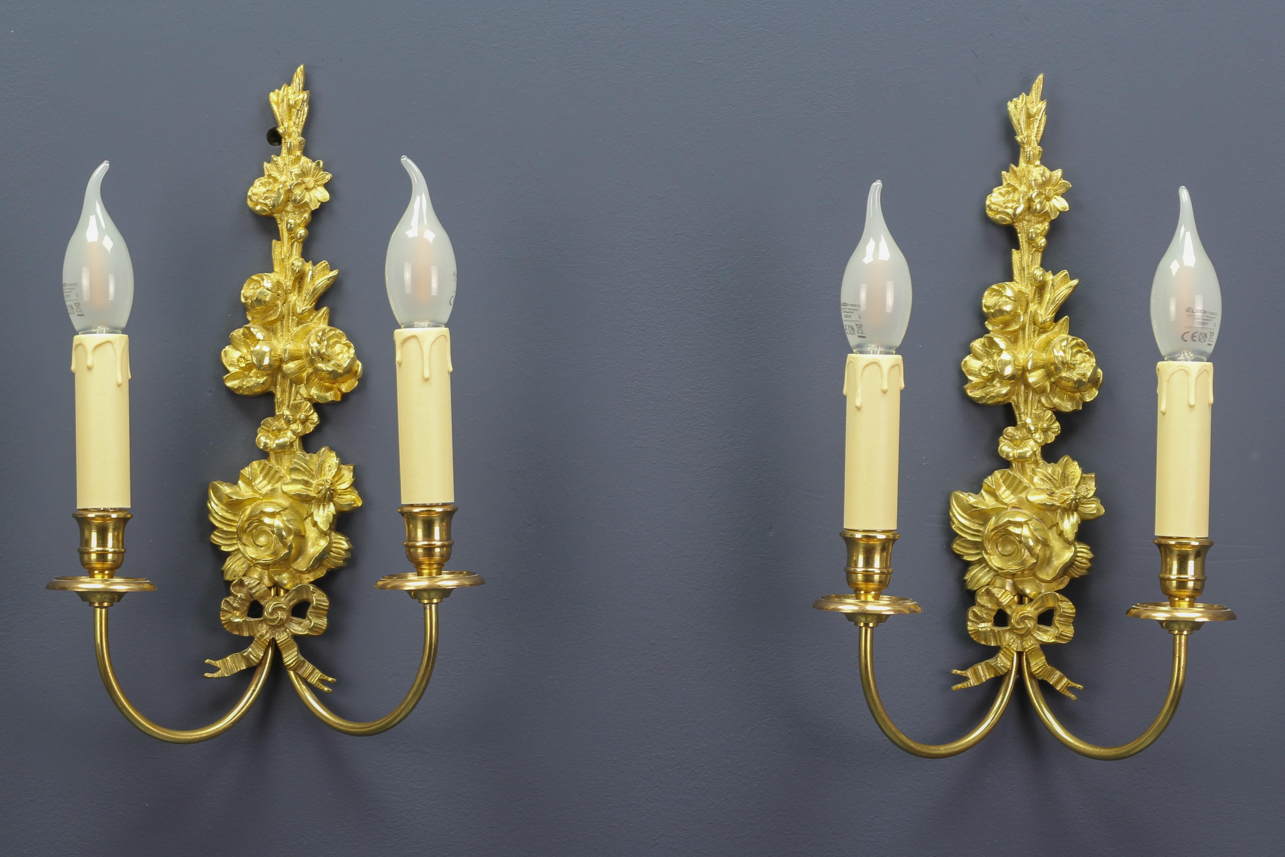 A pair of adorable French early 20th century Belle Époque style gilt bronze and brass sconces in a form of a beautifully shaped flower bouquet. The sconces are numbered on the backside.
Each sconce has two arms and each arm has a socket for an E 14