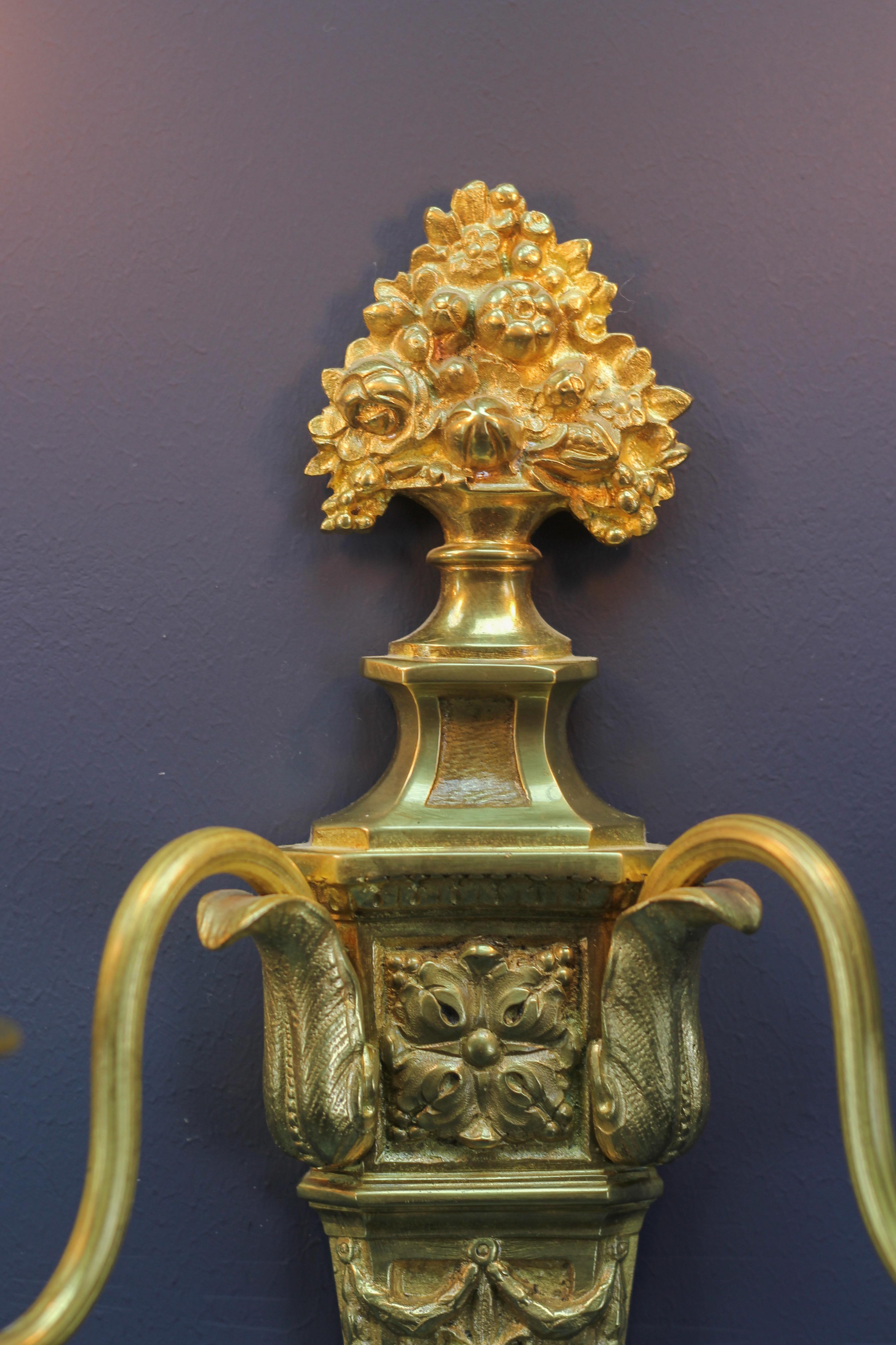 Paar französische zweiflammige Wandleuchter aus vergoldeter Bronze und Messing im Louis-XVI.-Stil (Frühes 20. Jahrhundert) im Angebot