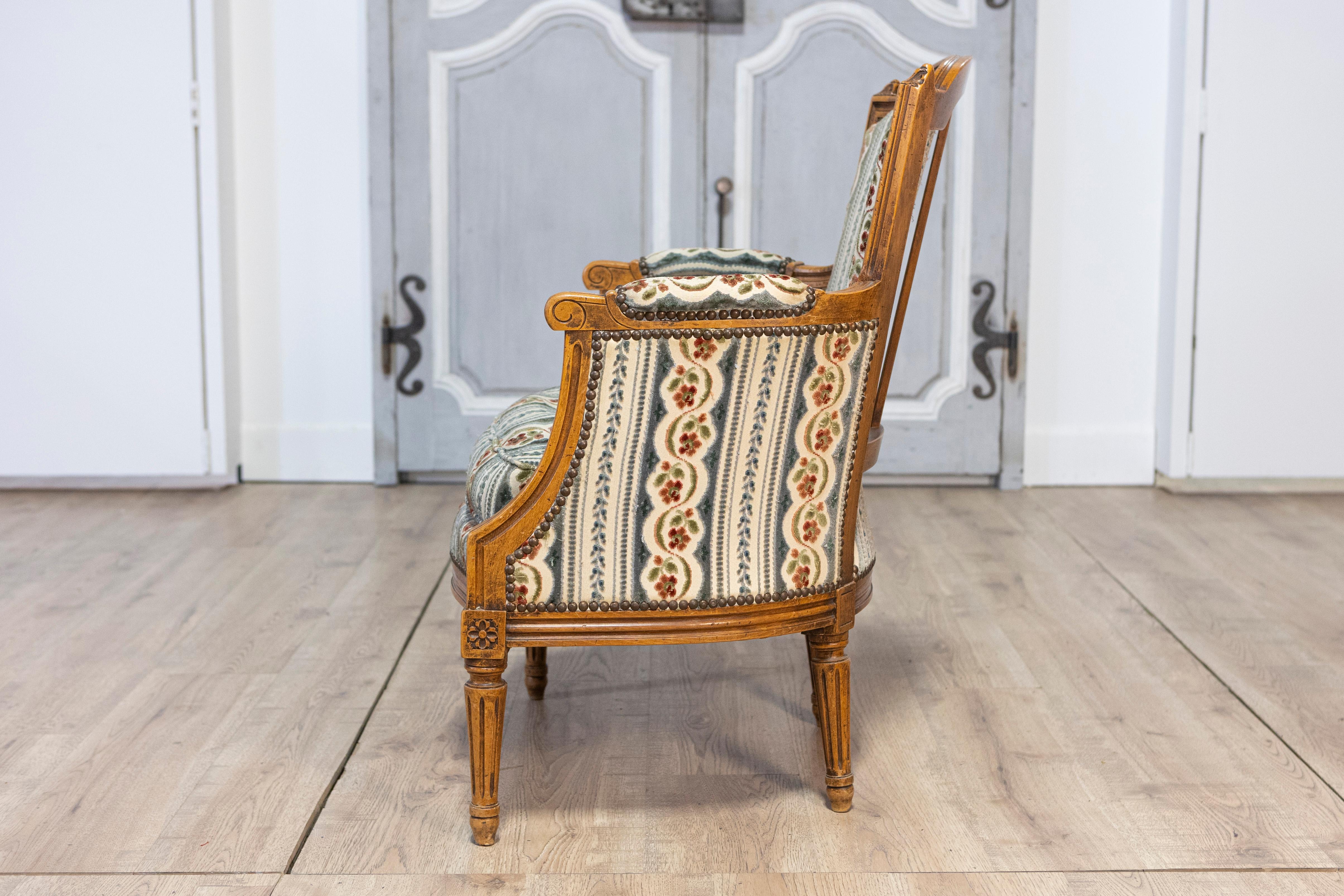 Pair of French Louis XVI Style Walnut Bergères Chairs with Carved Fluted Legs For Sale 6