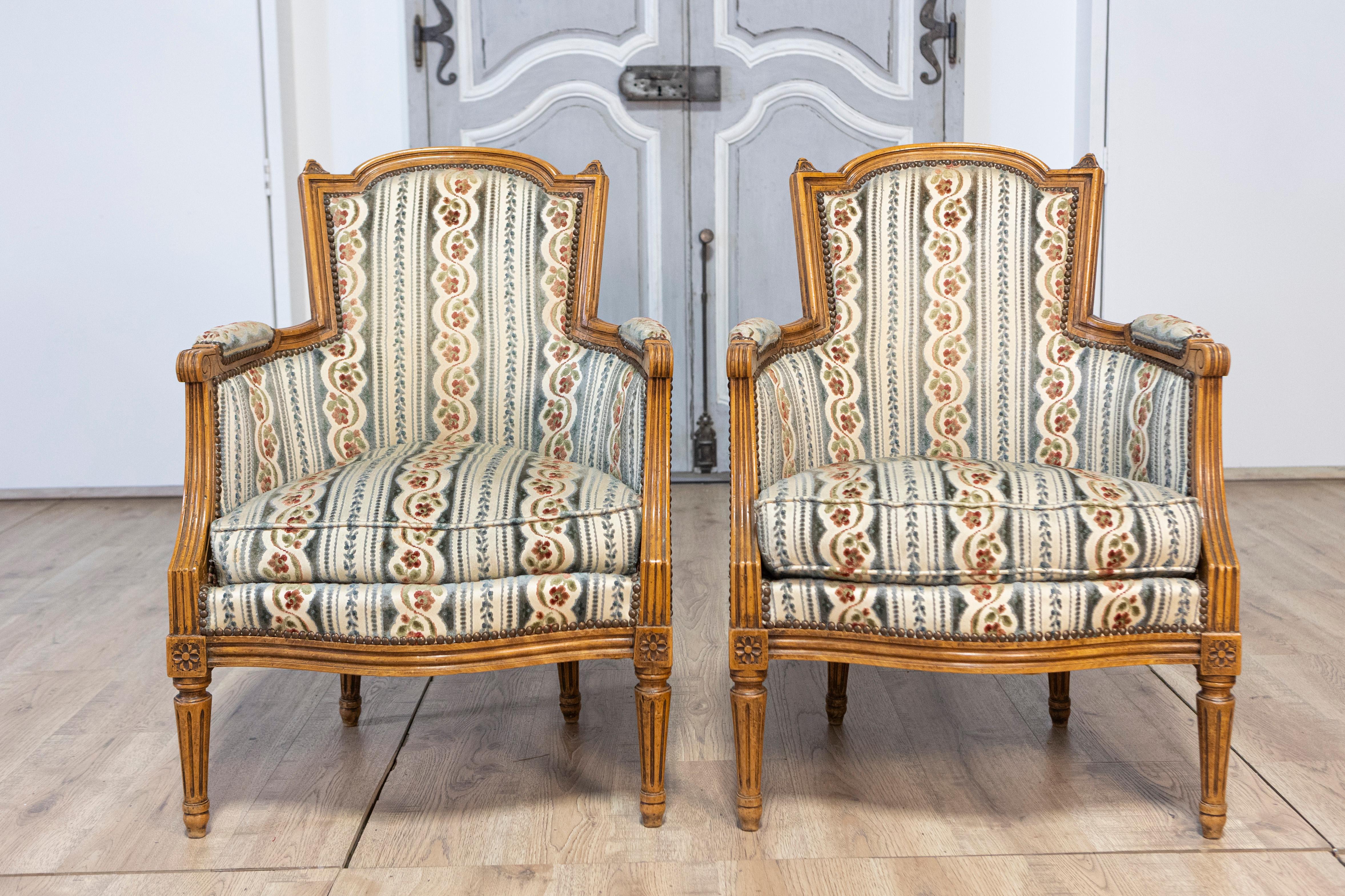 Pair of French Louis XVI Style Walnut Bergères Chairs with Carved Fluted Legs In Good Condition For Sale In Atlanta, GA