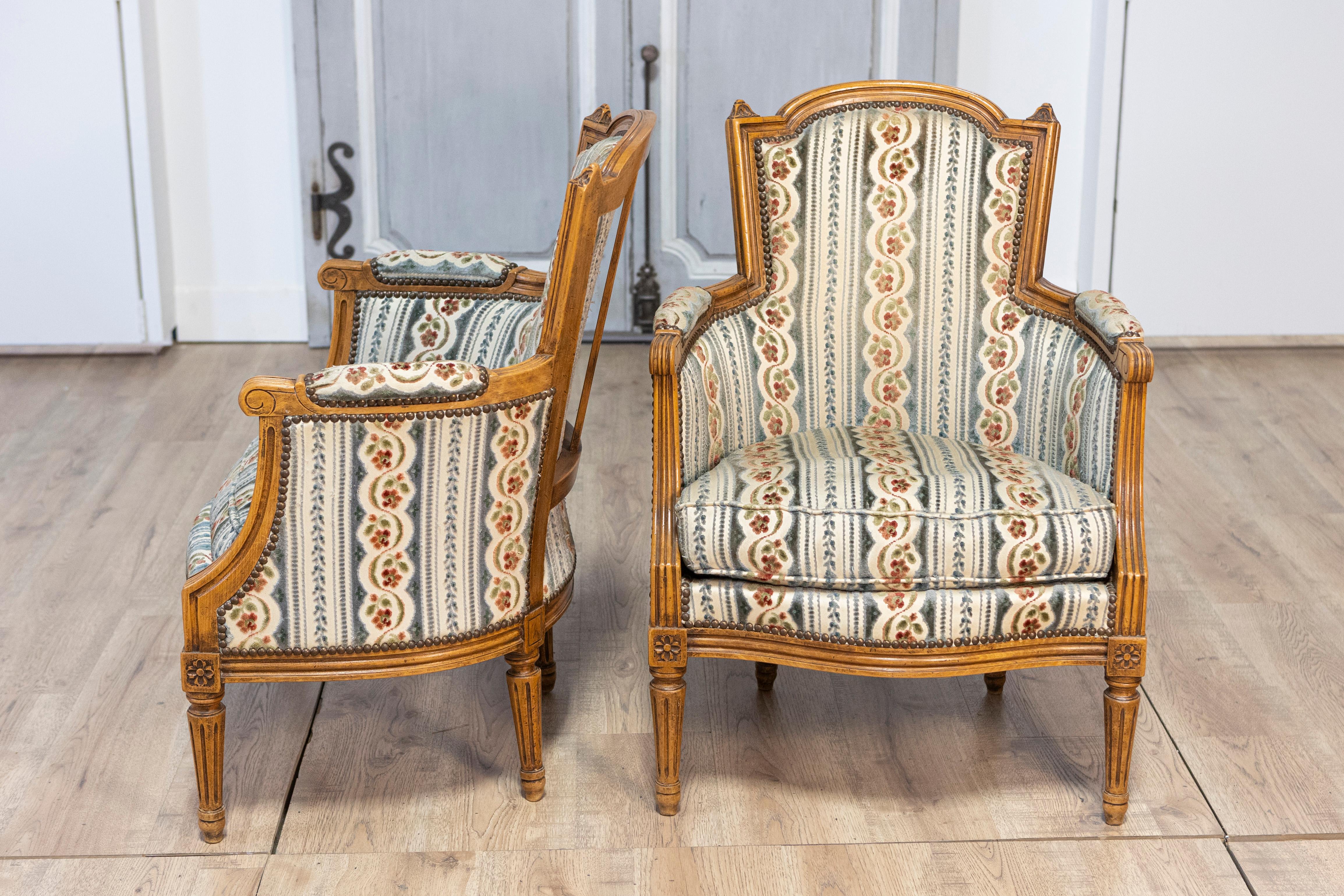 20th Century Pair of French Louis XVI Style Walnut Bergères Chairs with Carved Fluted Legs For Sale