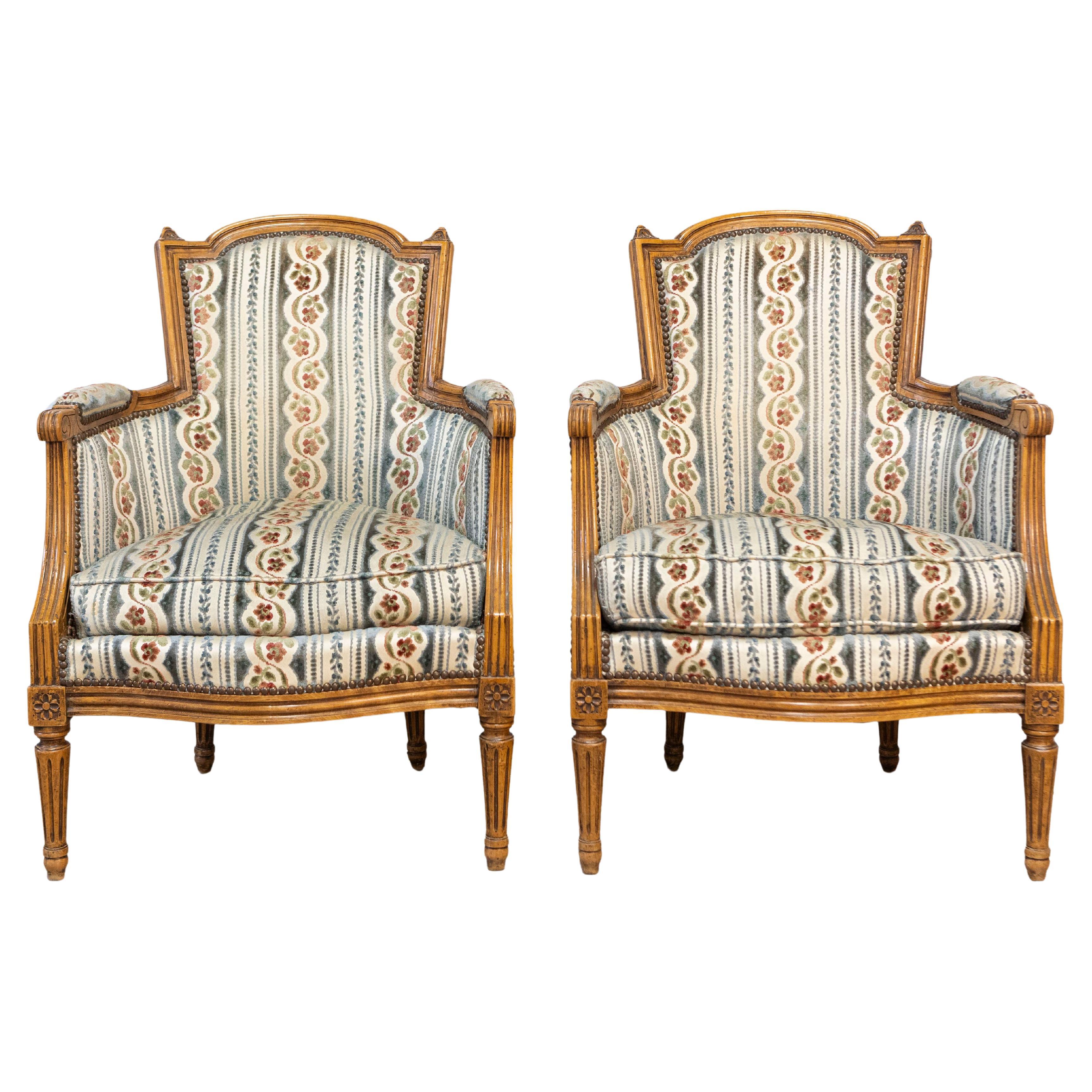 Pair of French Louis XVI Style Walnut Bergères Chairs with Carved Fluted Legs For Sale