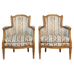 Pair of French Louis XVI Style Walnut Bergères Chairs with Carved Fluted Legs