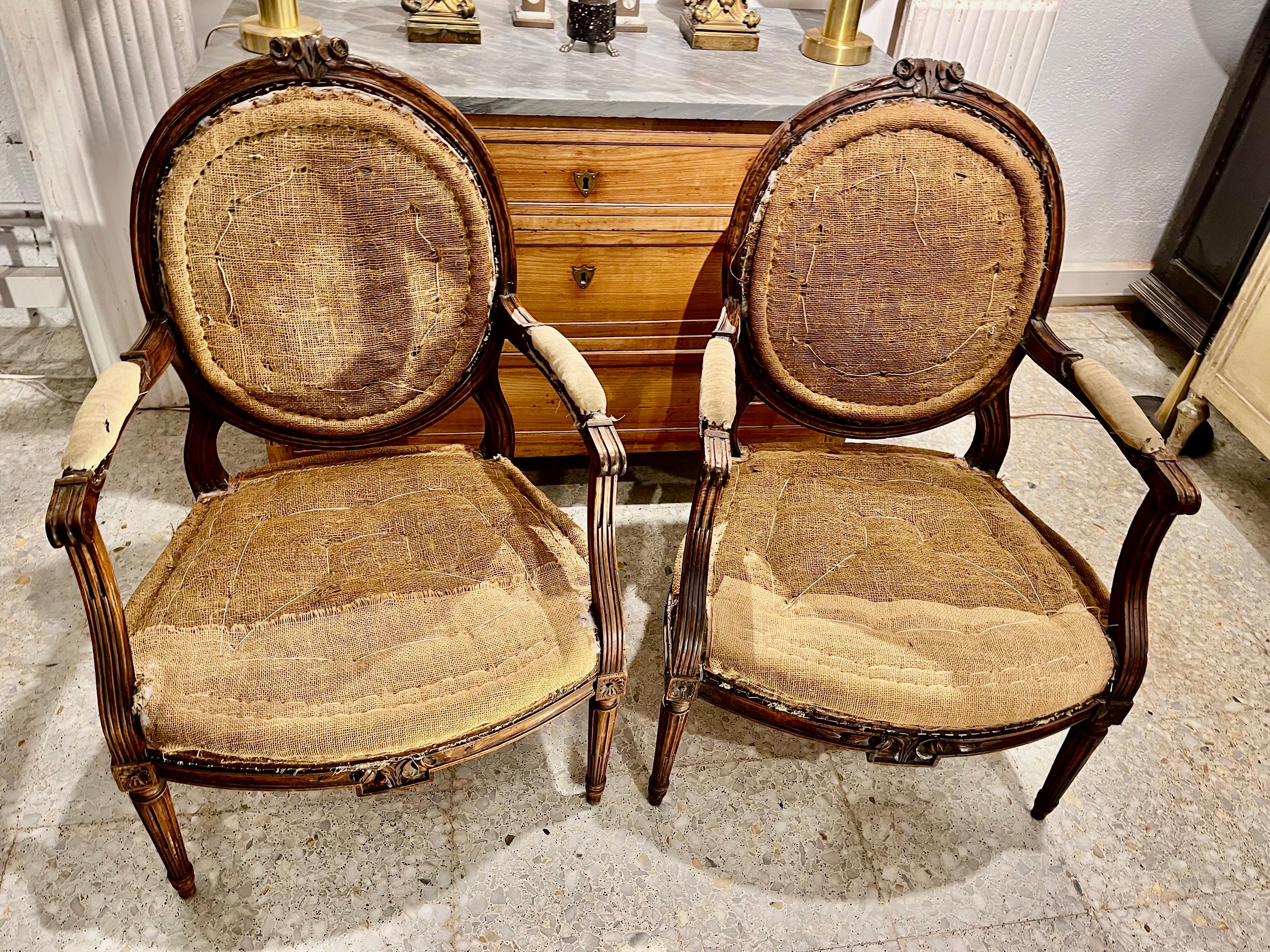 Pair of French Louis XVI Walnut Armchairs or Fauteuils, Hand Carved Nogal en venta