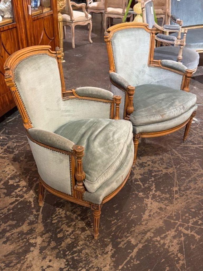Le produit est une paire de Bergeres Louis XVI en noyer, chaises authentiques et luxueuses, fabriquées en bois de noyer riche avec une tapisserie bleu pâle, ces chaises exsudent l'élégance et la sophistication. Parfaites pour une maison élégante,