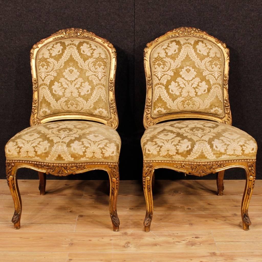 Pair of French chairs of the 20th century. Furniture in richly carved and gilded wood of good quality. Lounge chairs for bedroom or living room of beautiful decoration covered in damask velvet with some small signs of wear. Chairs of good comfort