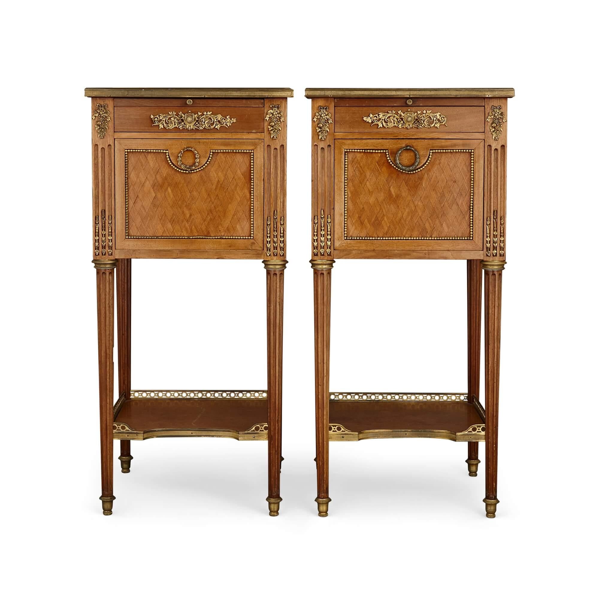 Pair of French mahogany and ormolu bedside cabinets 
French, 20th century 
Height 85cm, width 40cm, depth 40cm

Designed in the Louis XVI style, these bedside cabinets are superbly crafted out of an array of materials. 

Richly veined grey and