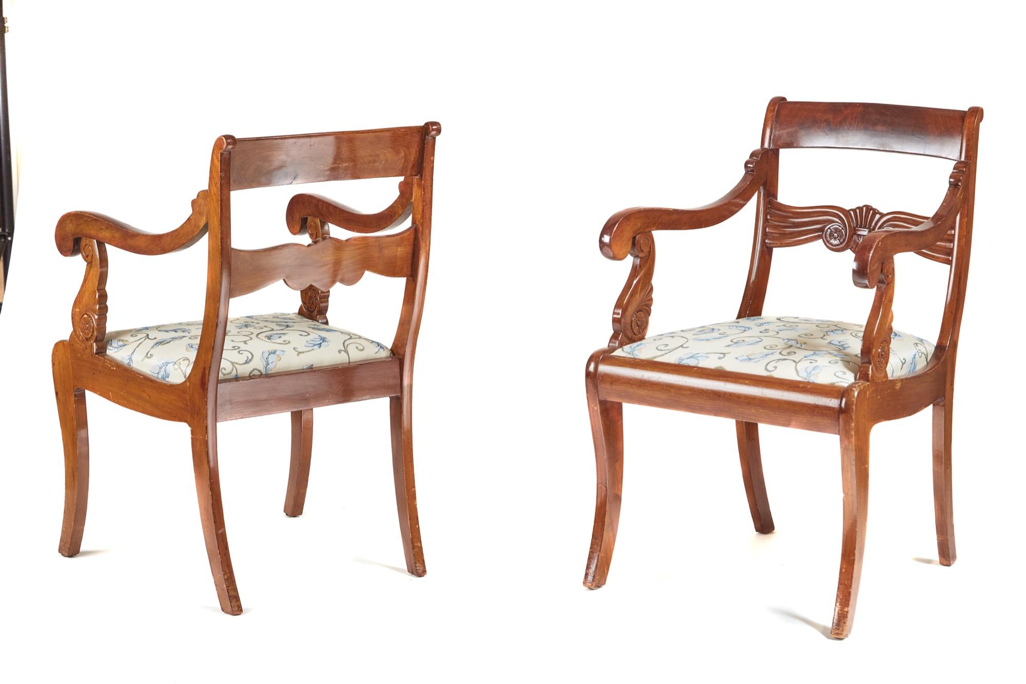 These are a pair of antique French 19th century antique mahogany carver chairs. The top rail boasts an attractive flame mahogany veneer center carved rail. They have pretty shaped scrolled arms, the drop seats are newly upholstered and the stand on