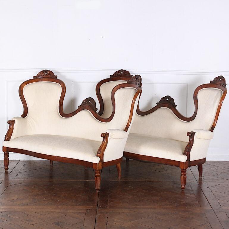A rare matched pair of French mahogany-framed spoon-back sofas with fine carved details to the backs and turned front legs, circa 1850-1860.

  