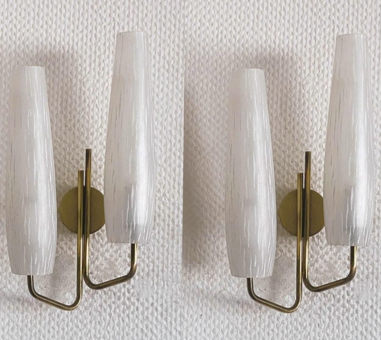 A lovely pair of double light wall sconces manufactured in France by the renowned lighting manufacturer Maison Arlus in the 1950s. Very elegant and timeless design, Tulip shaped made of gilt brass with beautiful, tall art glass shades. Both wall