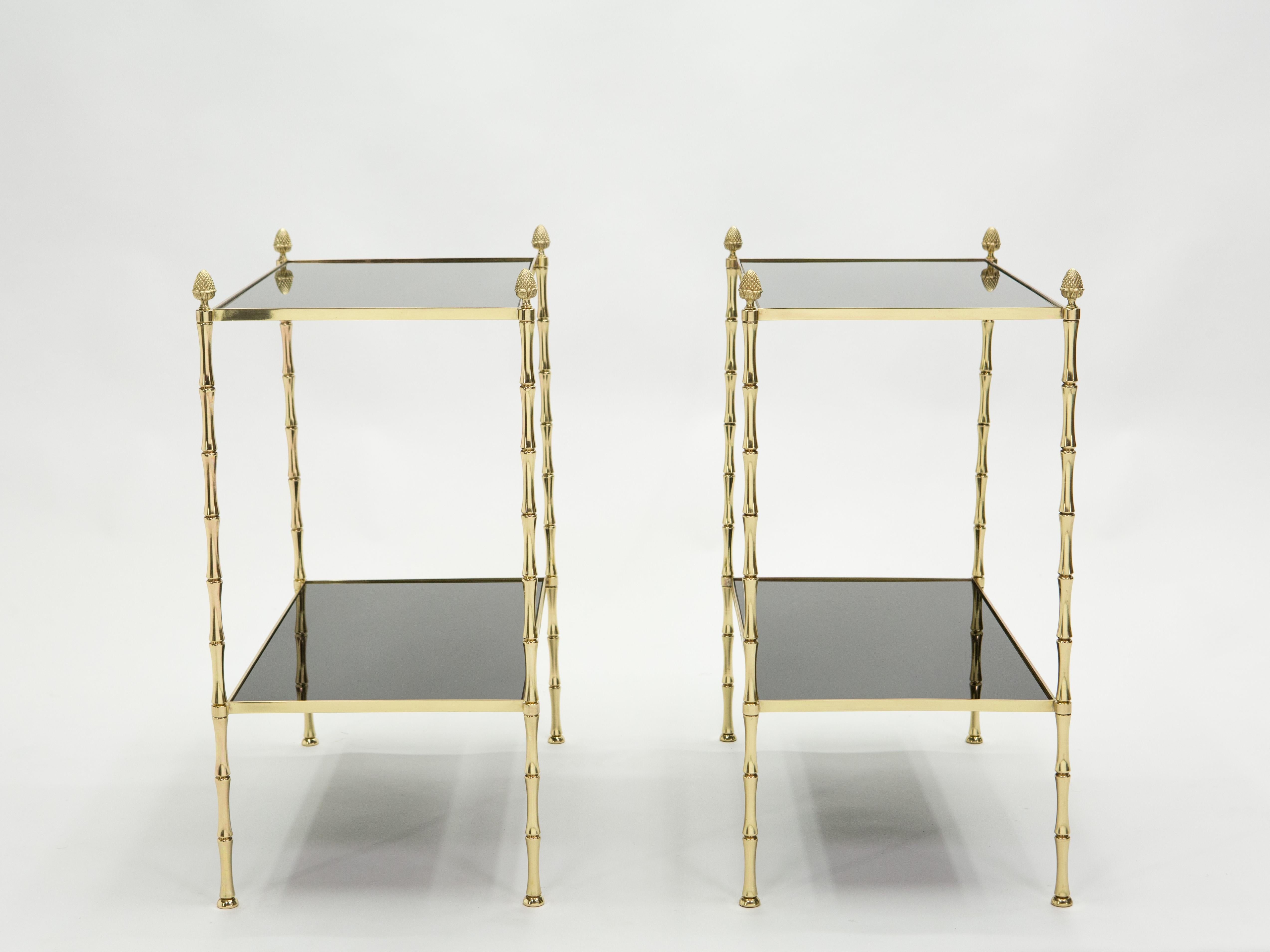This pair of two-tier end tables by French house Maison Baguès was created with solid bamboo shaped brass, typical French neoclassical pine cone, and beautiful black opaline glass tops, circa 1960. The two-tier black tops are timeless and smooth,