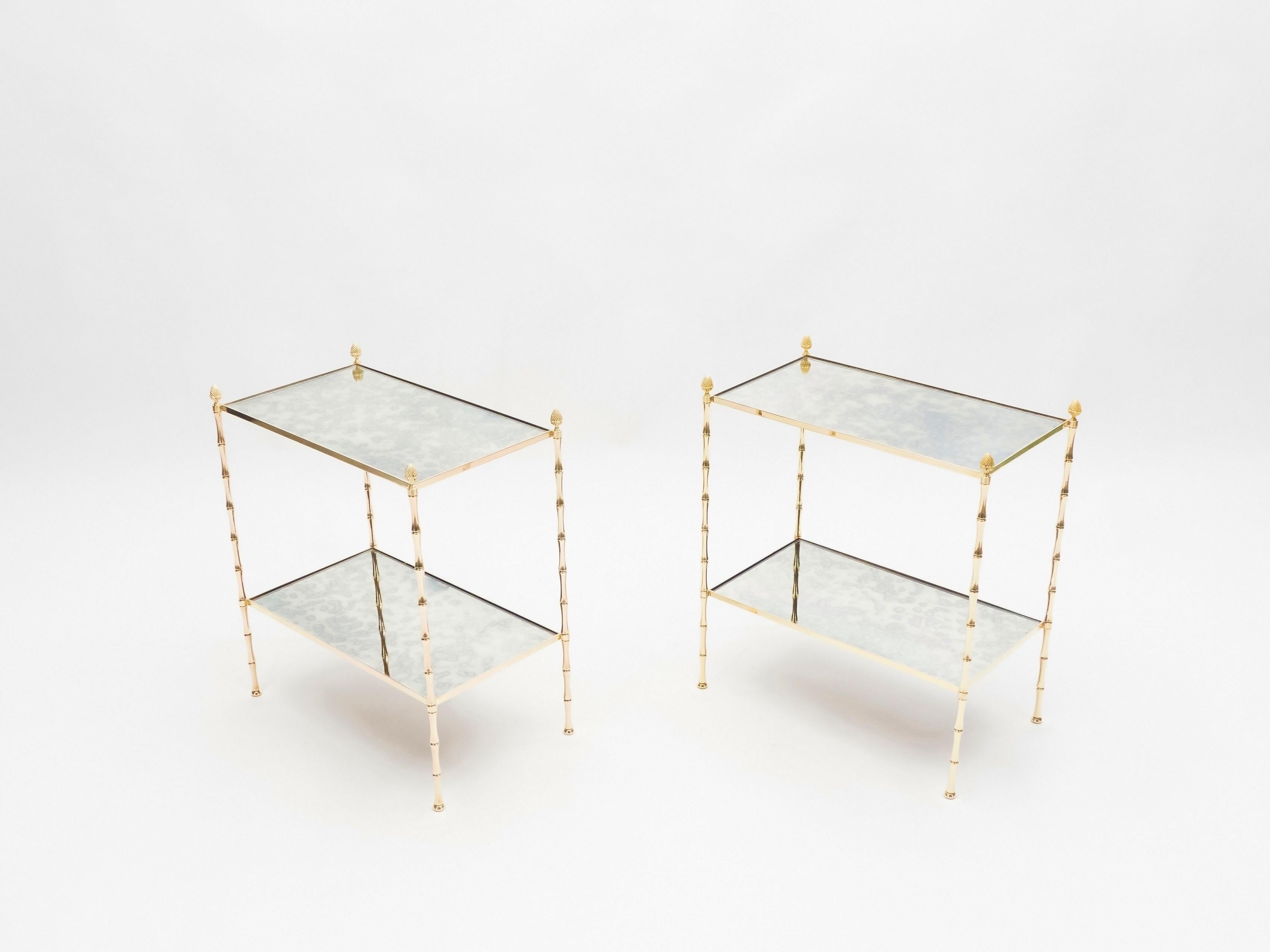 This pair of two-tier end tables by French design house Maison Baguès was created with solid bamboo shaped brass, typical french neoclassical pine cone, and beautiful old patina mirror circa 1960. The two-tier mirrors are timeless and smooth, while