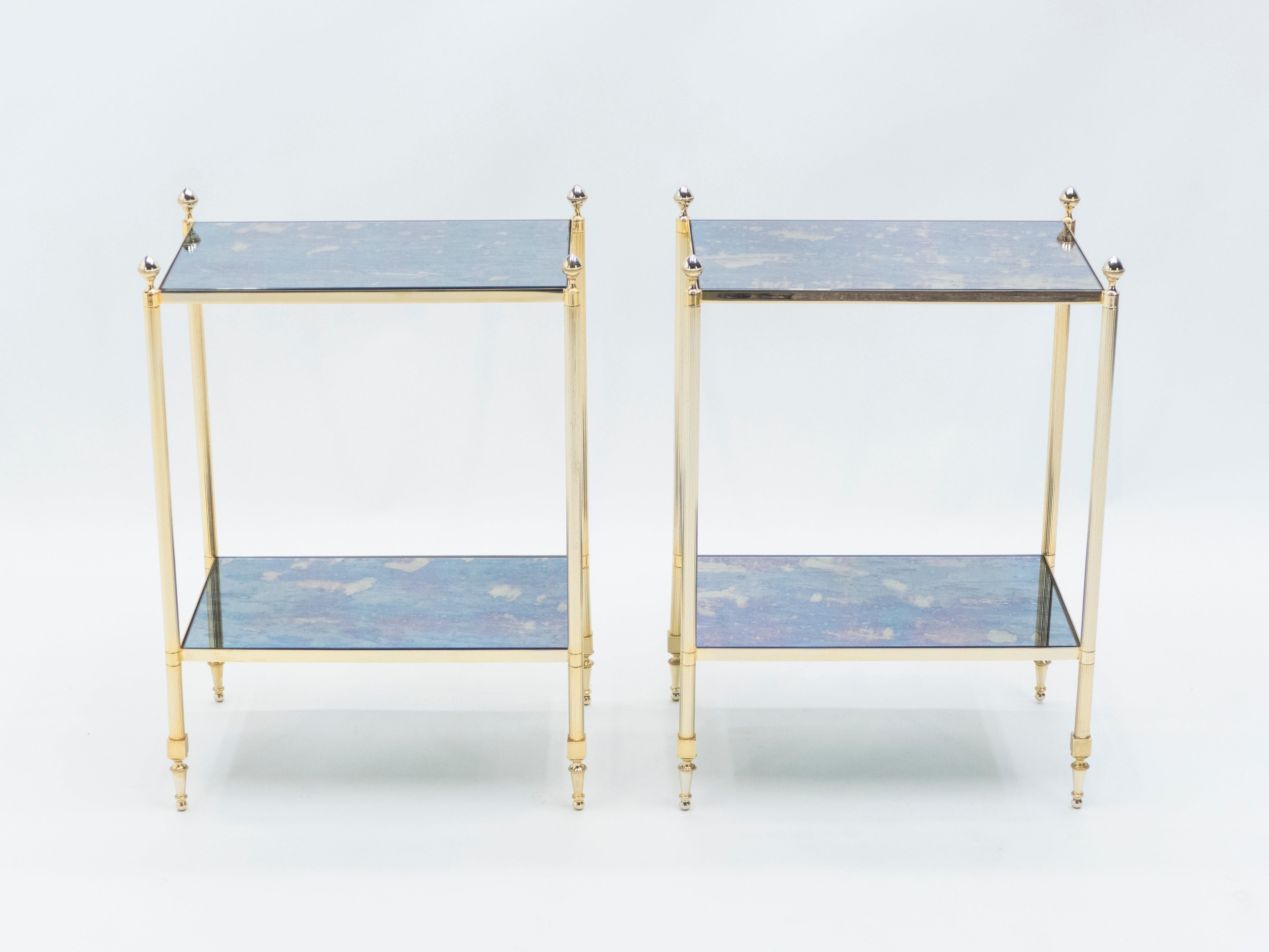 This pair of two-tier end tables by French design house Maison Jansen was created with solid brass, typical french neoclassical pine cone, and beautiful old patina mirror circa 1960. The two-tier mirrors are timeless and smooth, while the brass feet